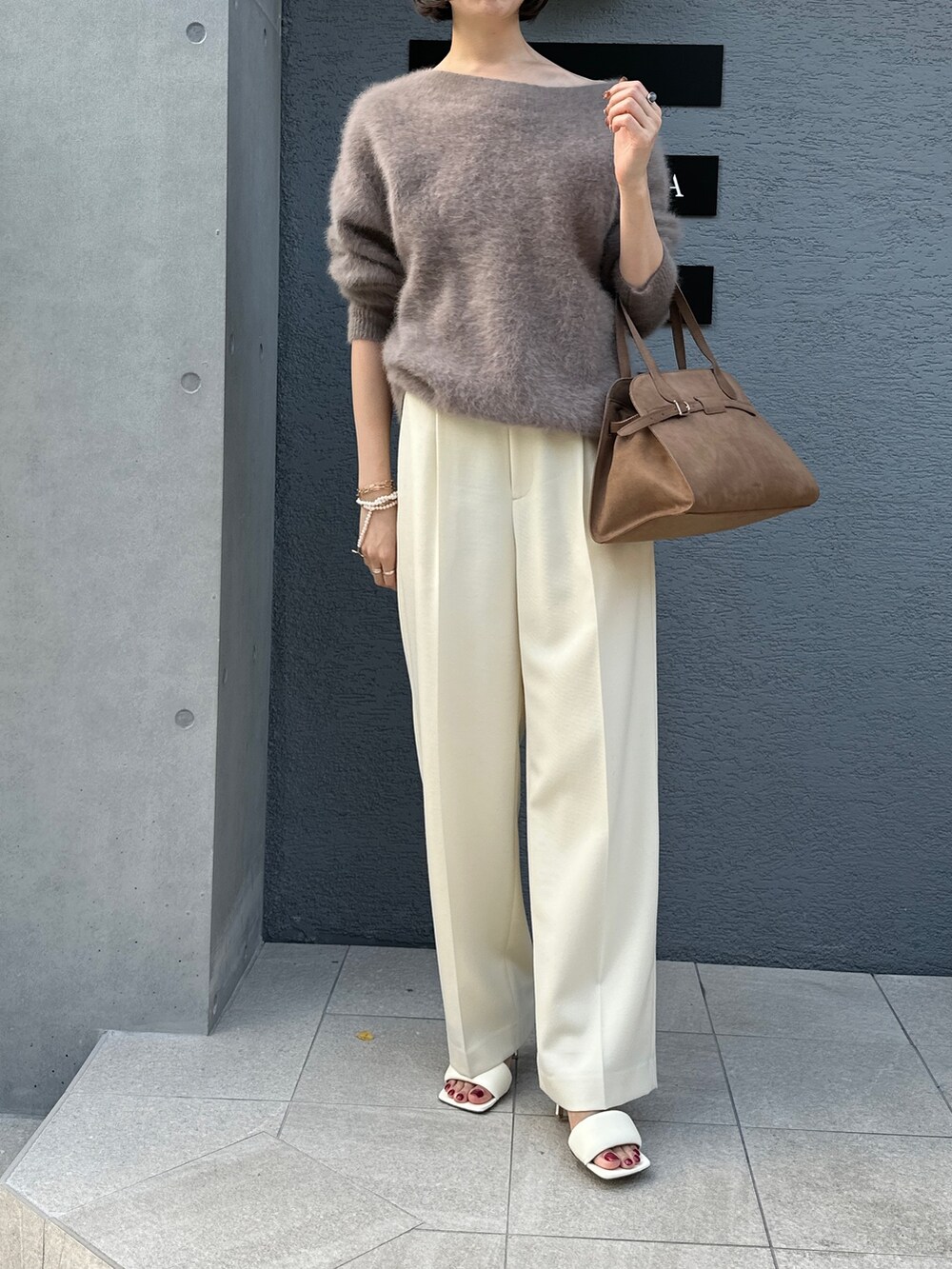 ブラウン系のニット/セーター、ブラウン系のボストンバッグ、ホワイト系のその他パンツを着用したレディースの秋コーディネートの2枚目の写真