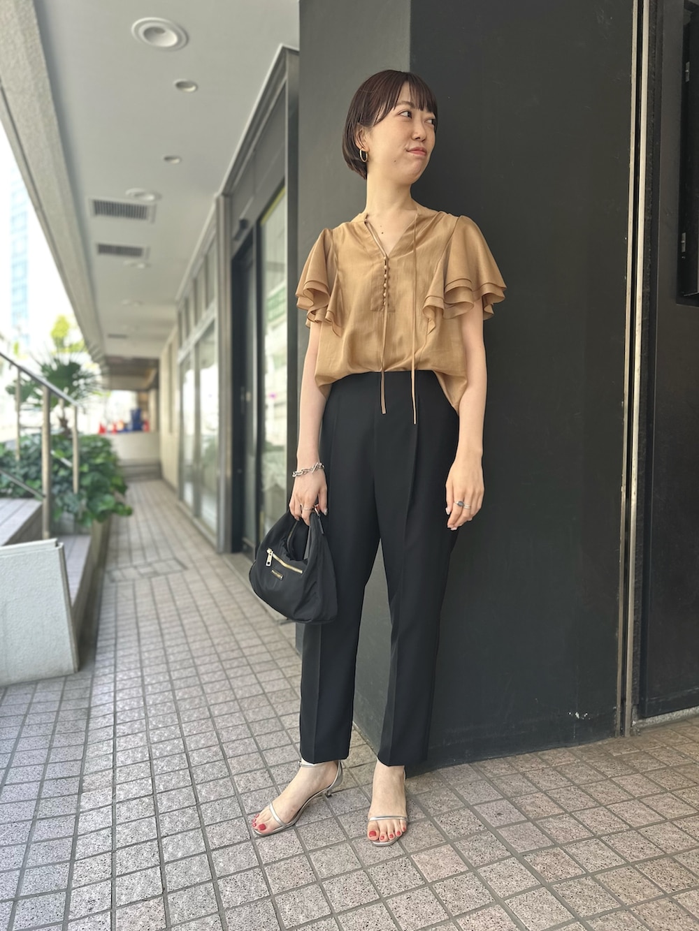 イエロー系のシャツ/ブラウス、ブラック系のその他パンツを着用したレディースの春コーディネートの2枚目の写真