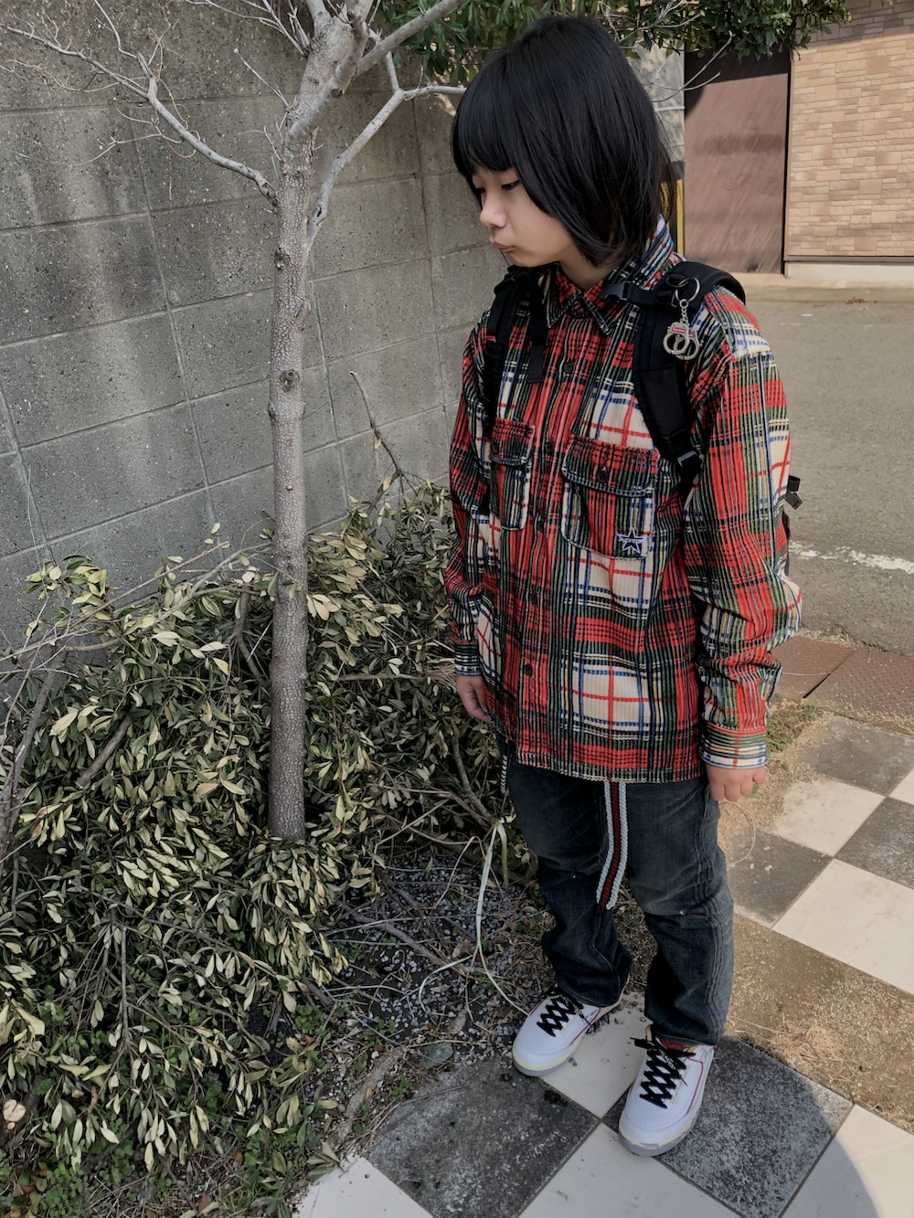 ブルー系のデニムパンツ、ホワイト系のスニーカー、レッド系のシャツ/ブラウスを着用したレディースの春コーディネートの2枚目の写真