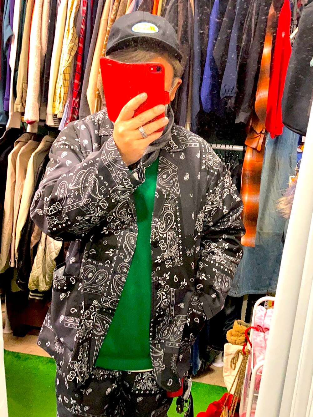 グリーン系のニット/セーター、ブラック系のセットアップ、ブラック系のスニーカーを着用したメンズの秋コーディネートの2枚目の写真