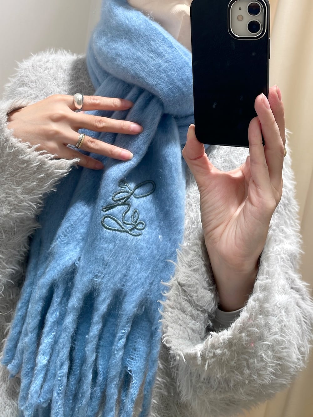 グレー系のカーディガン/ボレロ、ブラック系のスカート、ブルー系のマフラーを着用したレディースの冬コーディネートの3枚目の写真