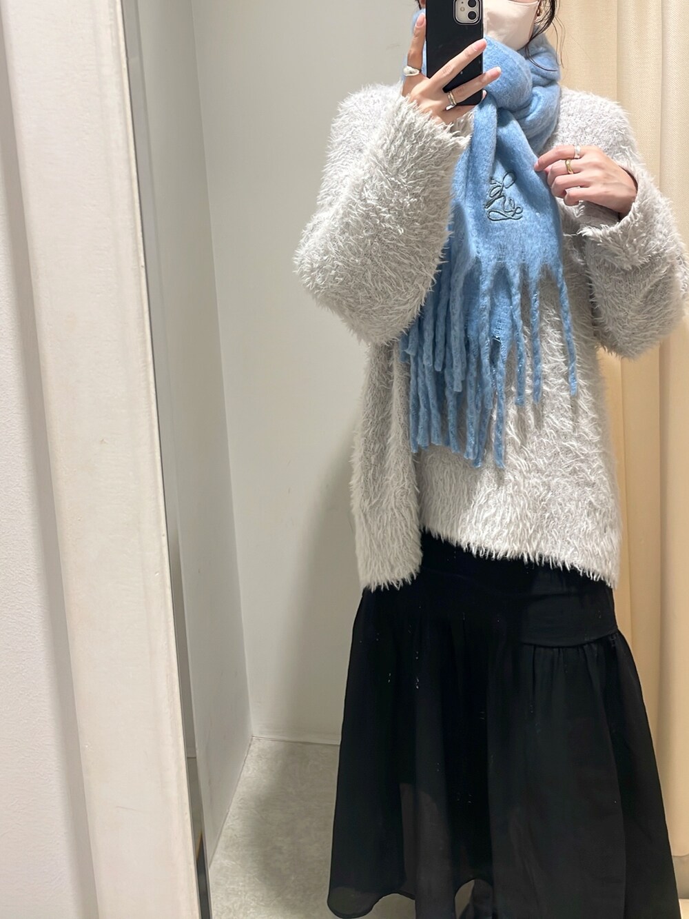 グレー系のカーディガン/ボレロ、ブラック系のスカート、ブルー系のマフラーを着用したレディースの冬コーディネートの2枚目の写真