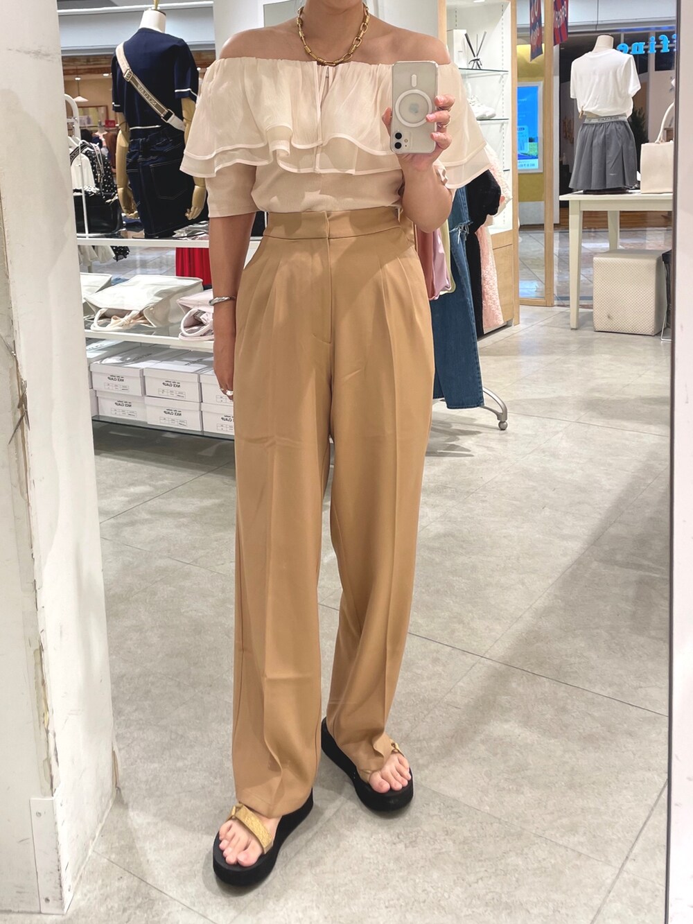 ベージュ系のスラックス、ホワイト系のTシャツ/カットソーを着用したレディースの夏コーディネートの3枚目の写真