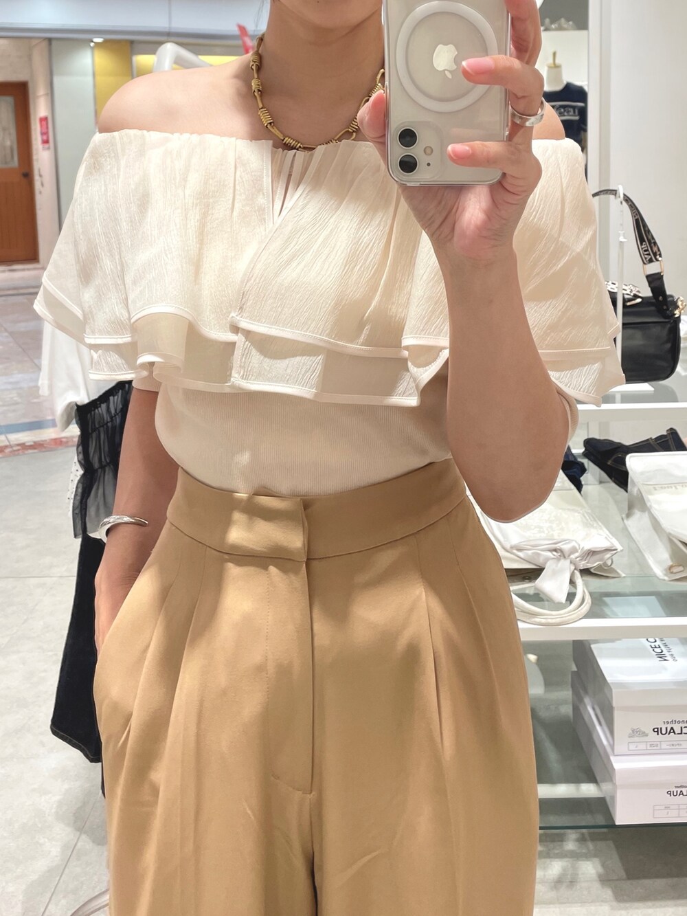 ベージュ系のスラックス、ホワイト系のTシャツ/カットソーを着用したレディースの夏コーディネートの4枚目の写真