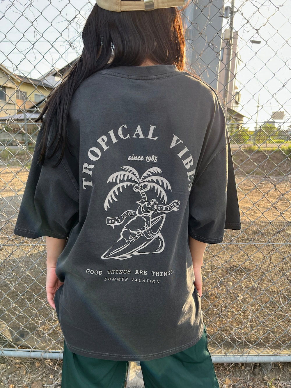 グレー系のTシャツ/カットソー、ホワイト系のスニーカー、ベージュ系のキャップを着用したレディースの春コーディネートの2枚目の写真