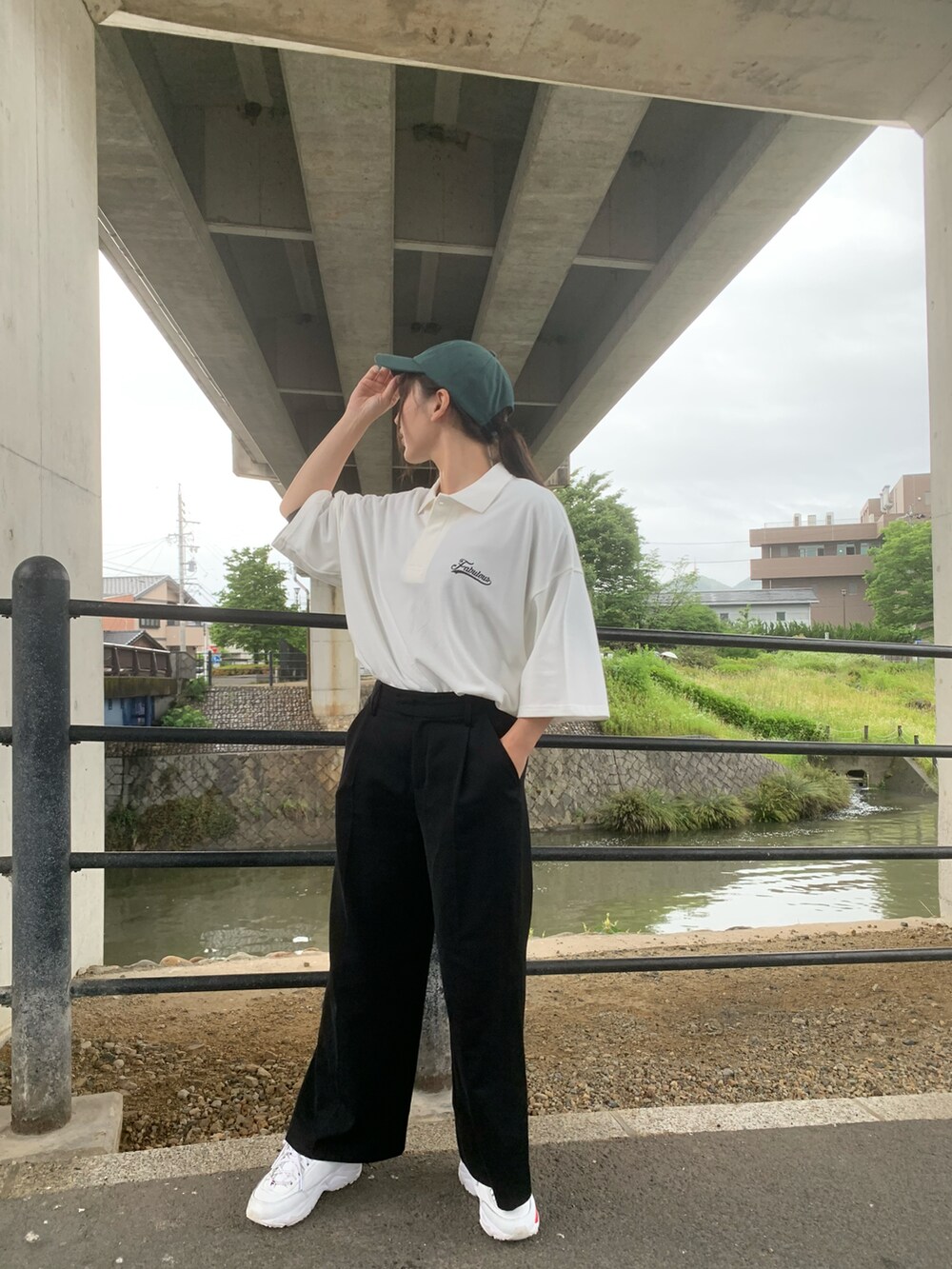 ホワイト系のポロシャツを着用したレディースの夏コーディネートの2枚目の写真