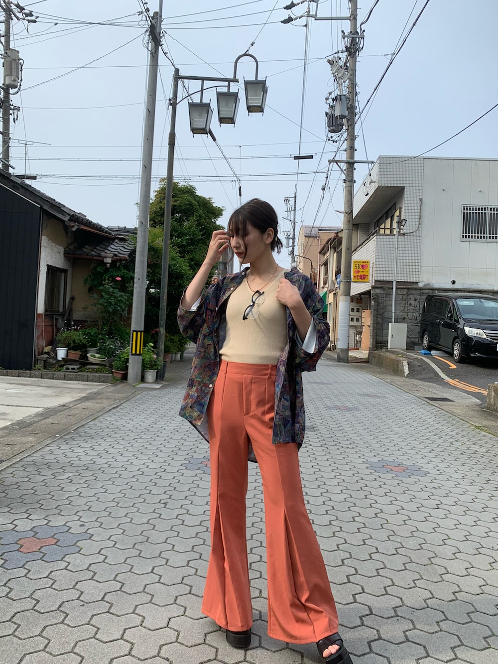 ブラウン系のシャツ/ブラウス、オレンジ系のパンツを着用したレディースの春コーディネートの2枚目の写真