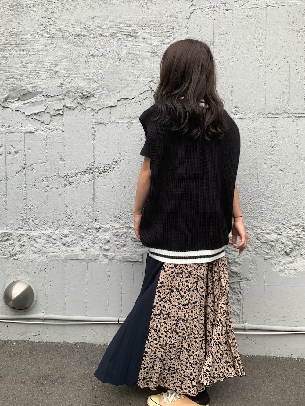 ブラック系のベストを着用したレディースの夏コーディネートの2枚目の写真
