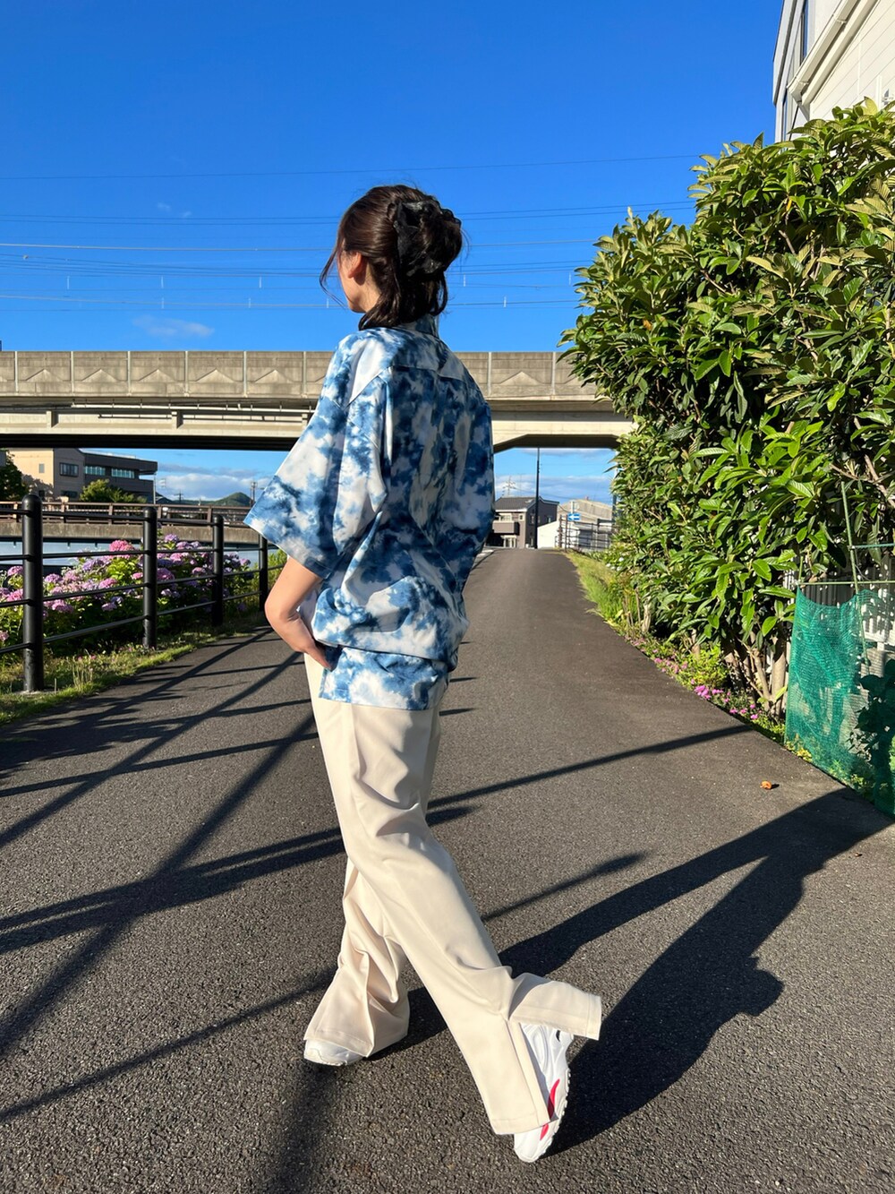 ブルー系のシャツ/ブラウスを着用したレディースの夏コーディネートの2枚目の写真