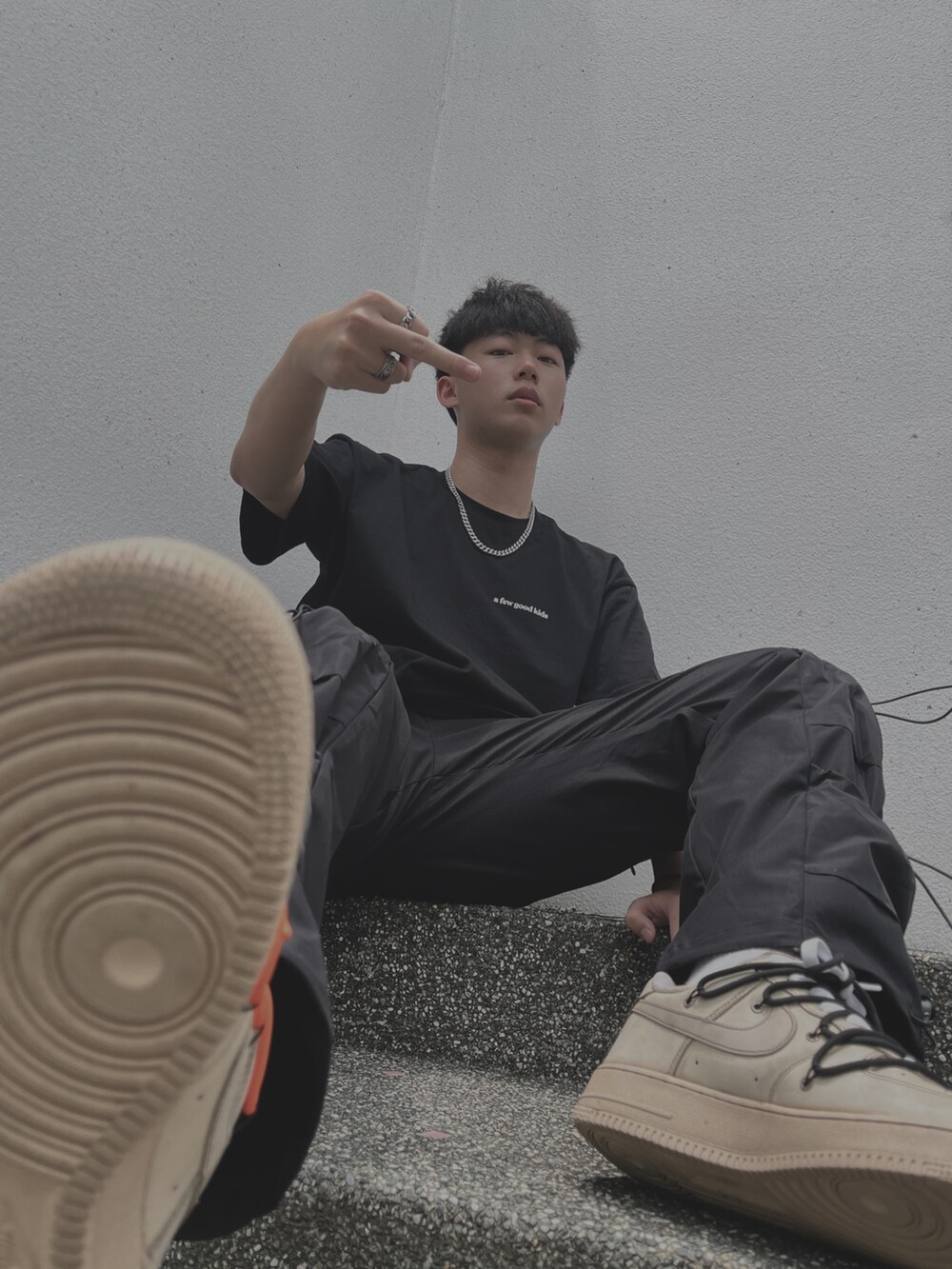 ブラック系のTシャツ/カットソー、ブラック系のパンツ、ホワイト系のスニーカーを着用したメンズの春コーディネートの2枚目の写真