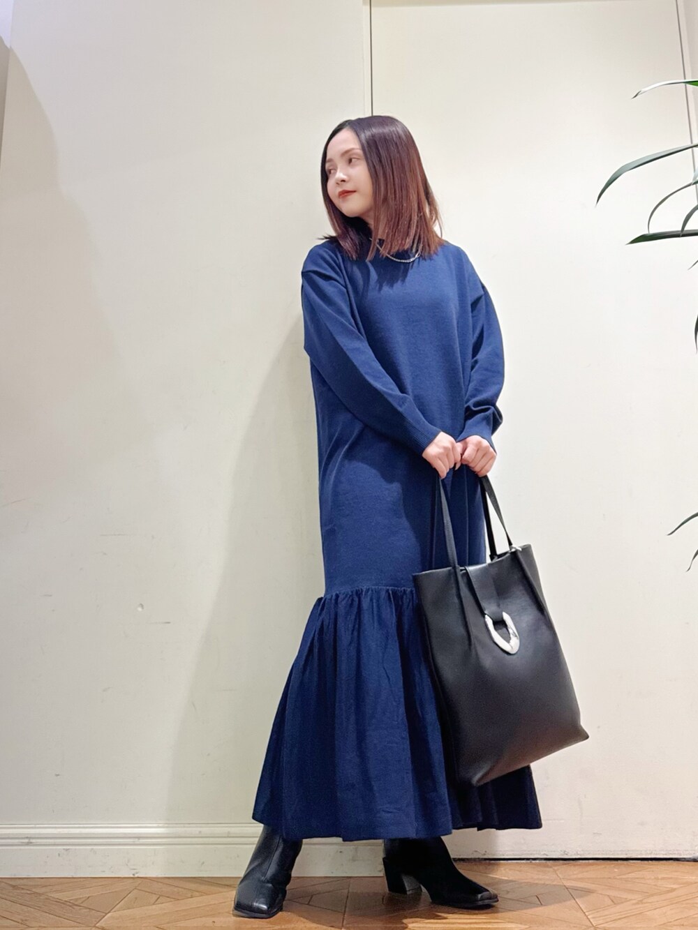 ブルー系のワンピース、ホワイト系のダウンジャケット/コート、シルバー系のネックレスを着用したレディースの冬コーディネートの2枚目の写真