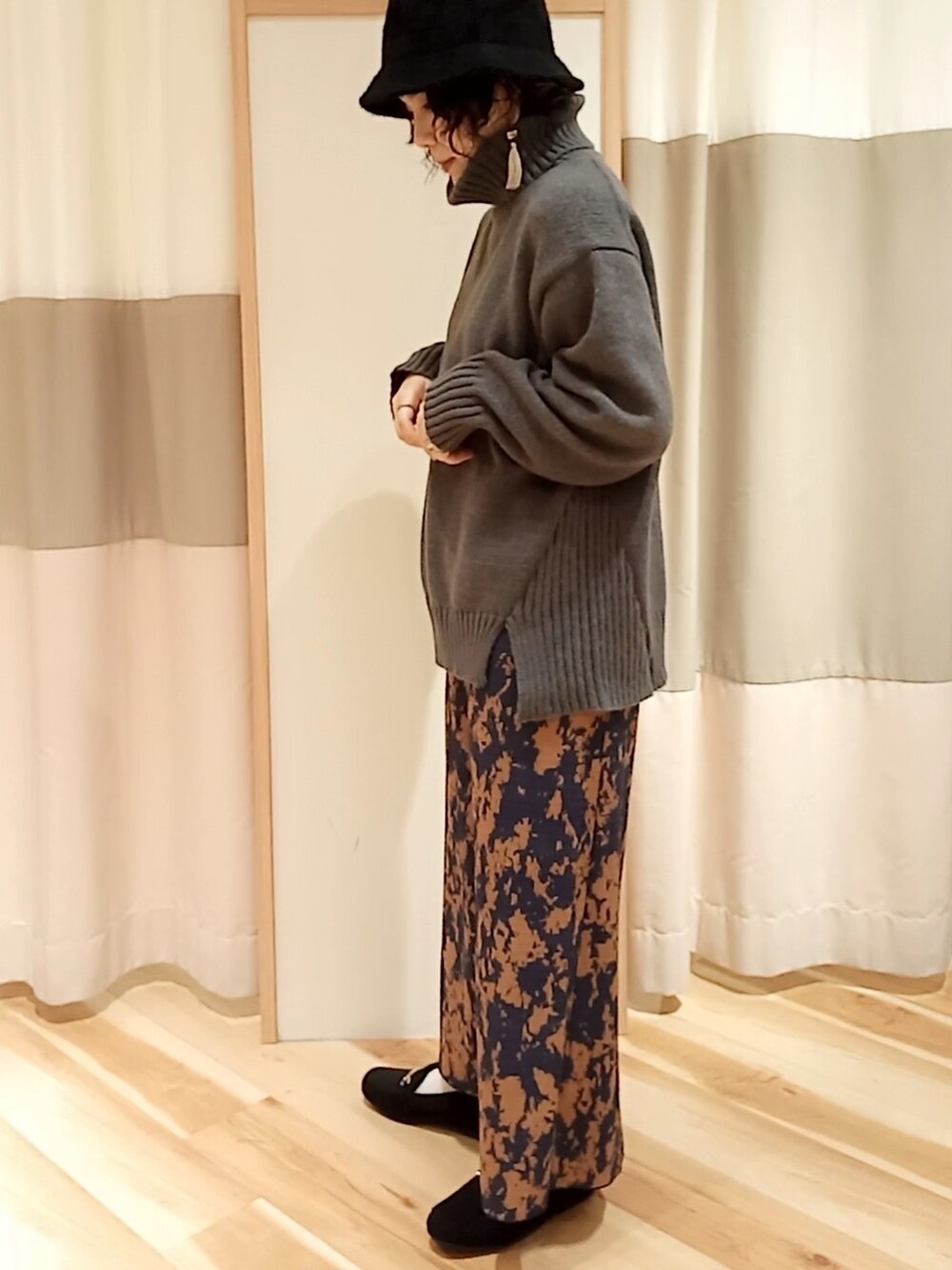 ブラウン系のスカート、ブラック系のドレスシューズ、グレー系のニット/セーターを着用したレディースの秋コーディネートの2枚目の写真