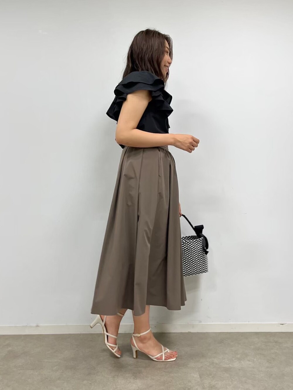 ブラック系のシャツ/ブラウス、ブラウン系のスカート、ブラック系のハンドバッグを着用したレディースの夏コーディネートの2枚目の写真