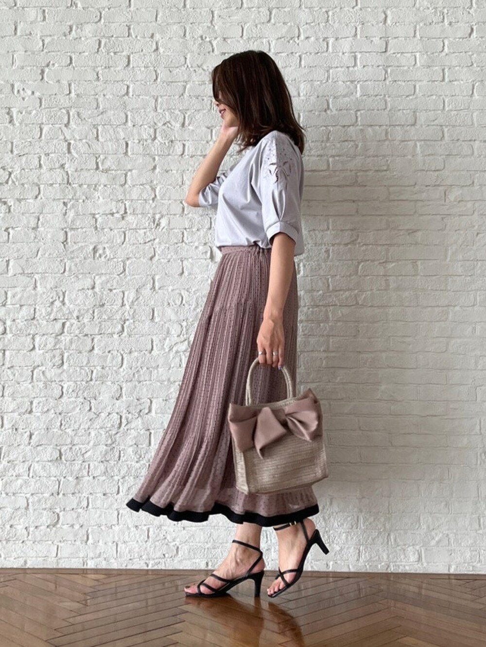 ベージュ系のトートバッグ、グレー系のTシャツ/カットソー、ブラウン系のスカートを着用したレディースの夏コーディネートの2枚目の写真