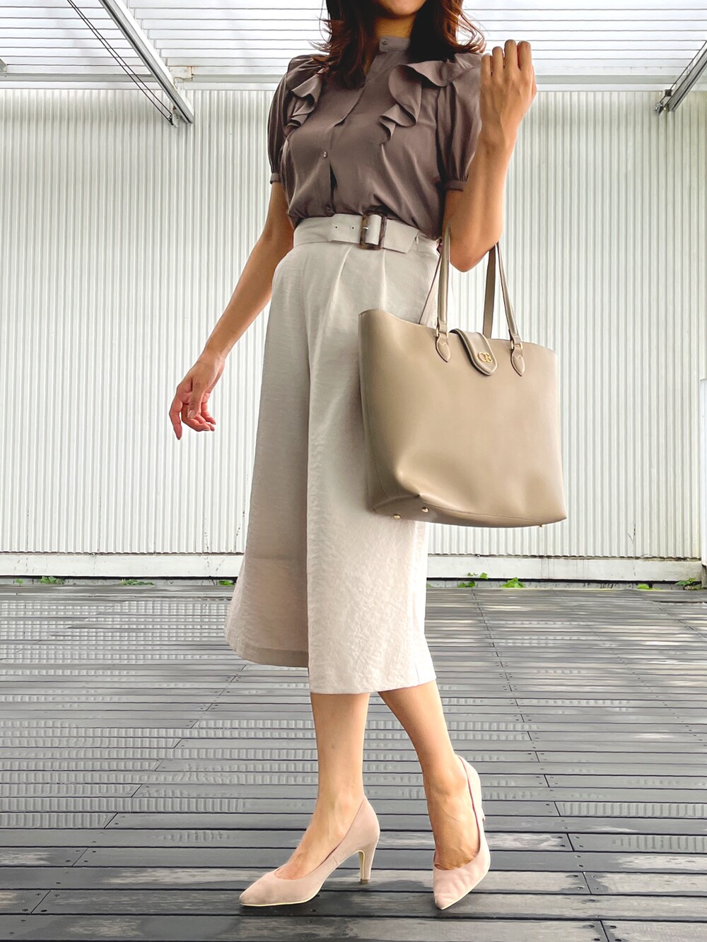 ベージュ系のシャツ/ブラウス、ベージュ系のパンツ、ベージュ系のトートバッグを着用したレディースの夏コーディネートの2枚目の写真
