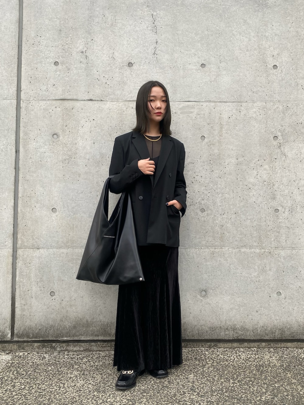 ブラック系のテーラードジャケット、ブラック系のトートバッグ、ブラック系のスカートを着用したレディースの春コーディネートの3枚目の写真