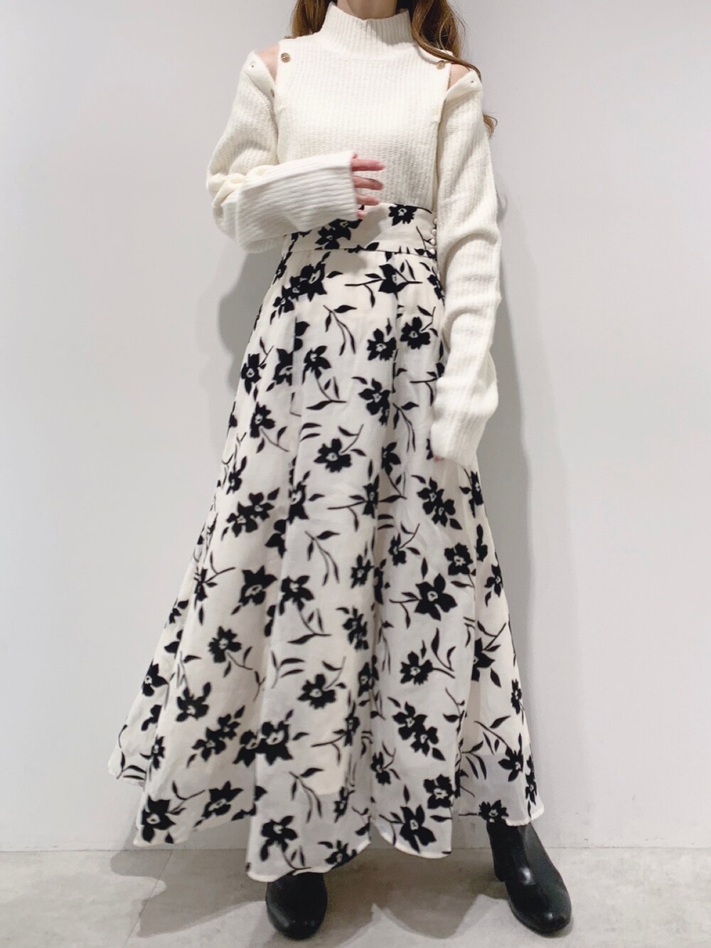 ホワイト系のチェスターコート、ホワイト系のニット/セーター、ホワイト系のスカートを着用したレディースの秋コーディネートの2枚目の写真