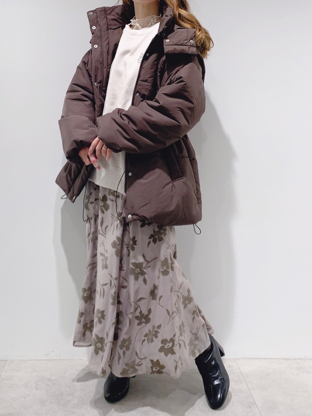 ブラウン系のダウンジャケット/コート、ホワイト系のスウェット、ホワイト系のTシャツ/カットソーを着用したレディースの秋コーディネートの2枚目の写真