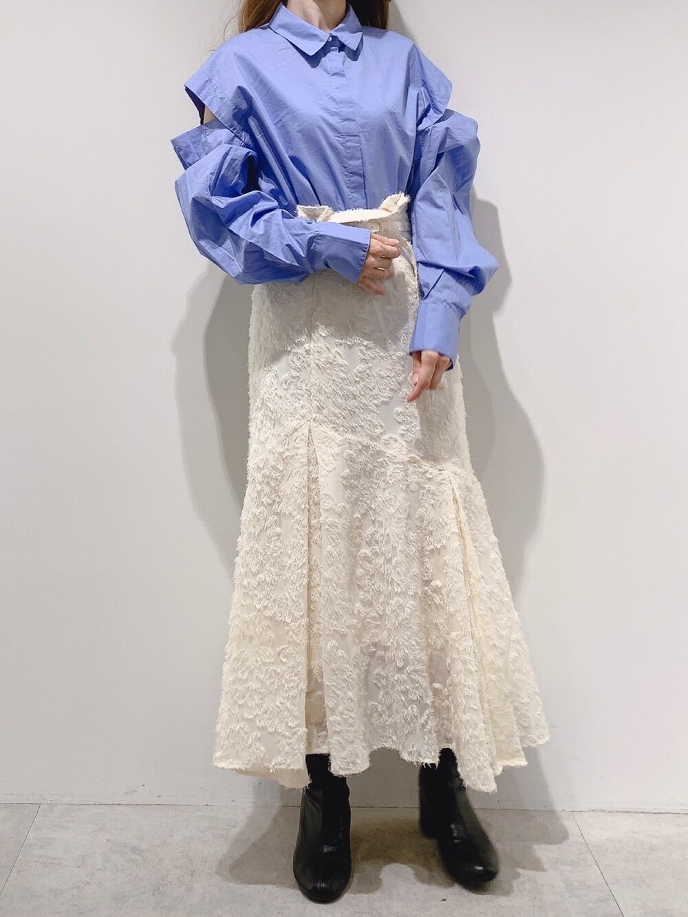 ホワイト系のカーディガン/ボレロ、ホワイト系のスカート、ホワイト系のブーツを着用したレディースの冬コーディネートの2枚目の写真