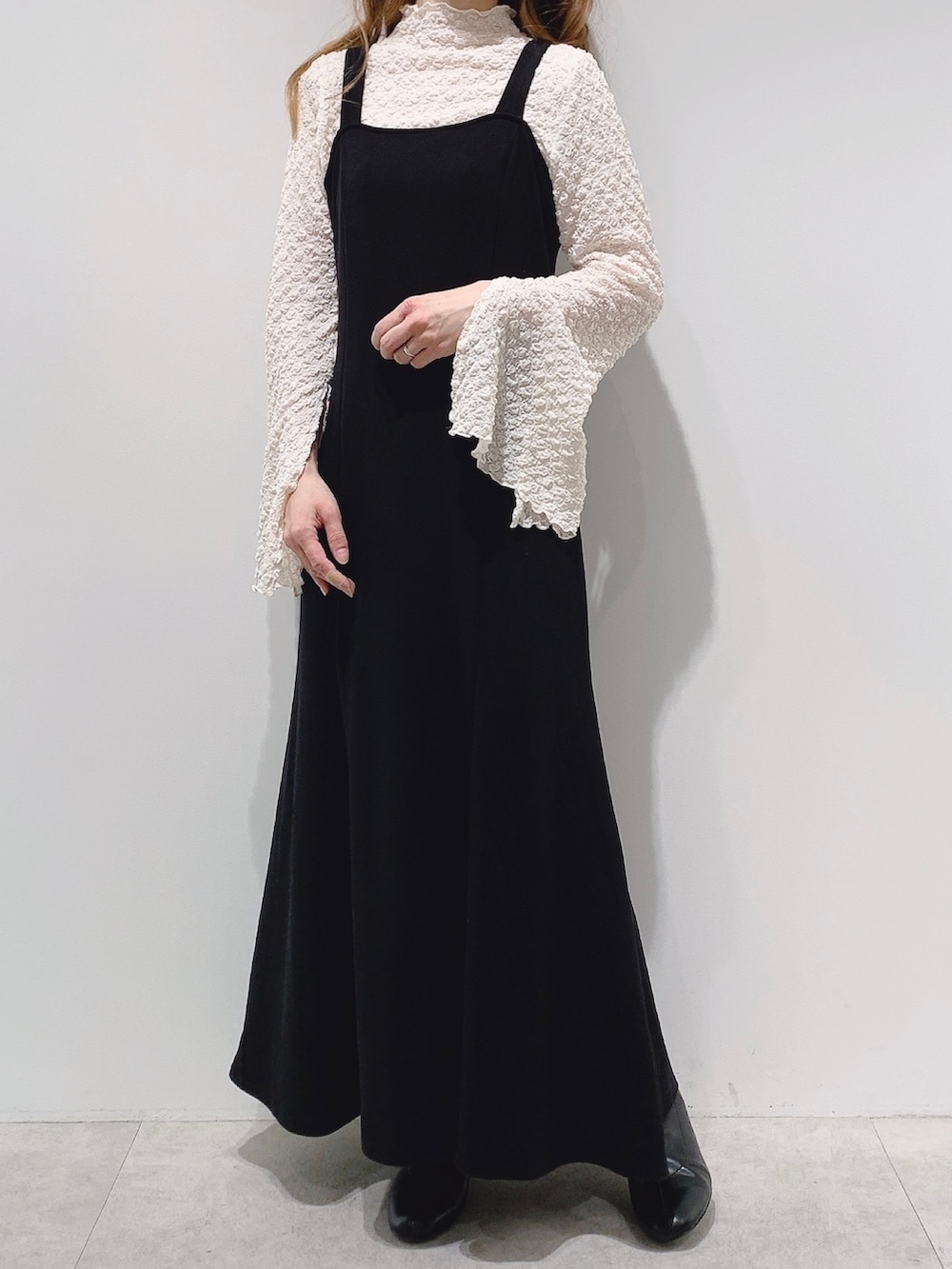 ブラック系のワンピース、ベージュ系のTシャツ/カットソー、ベージュ系のショルダーバッグを着用したレディースの冬コーディネートの2枚目の写真