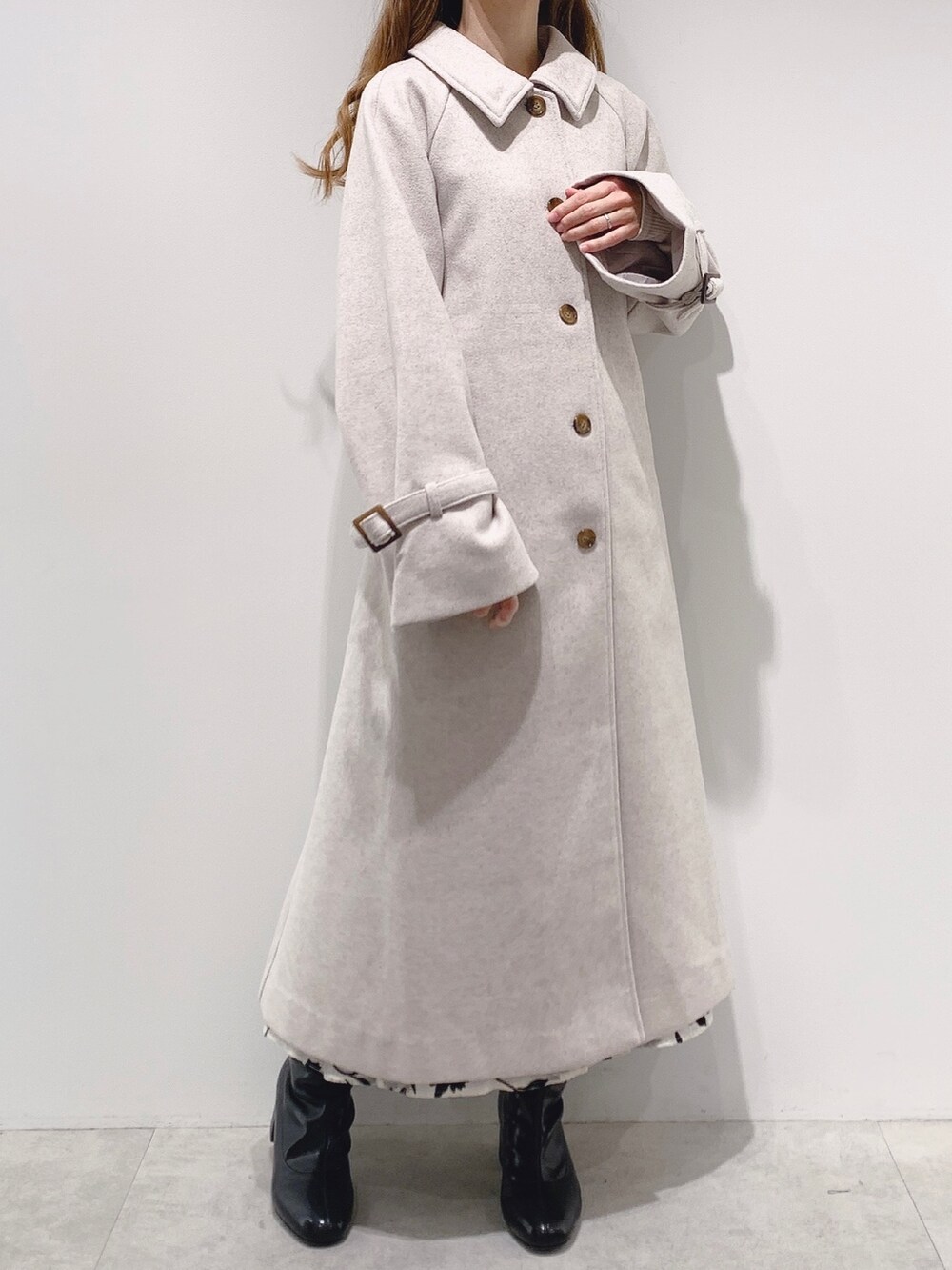 ベージュ系のステンカラーコート、ホワイト系のTシャツ/カットソー、ホワイト系のスカートを着用したレディースの秋コーディネートの2枚目の写真