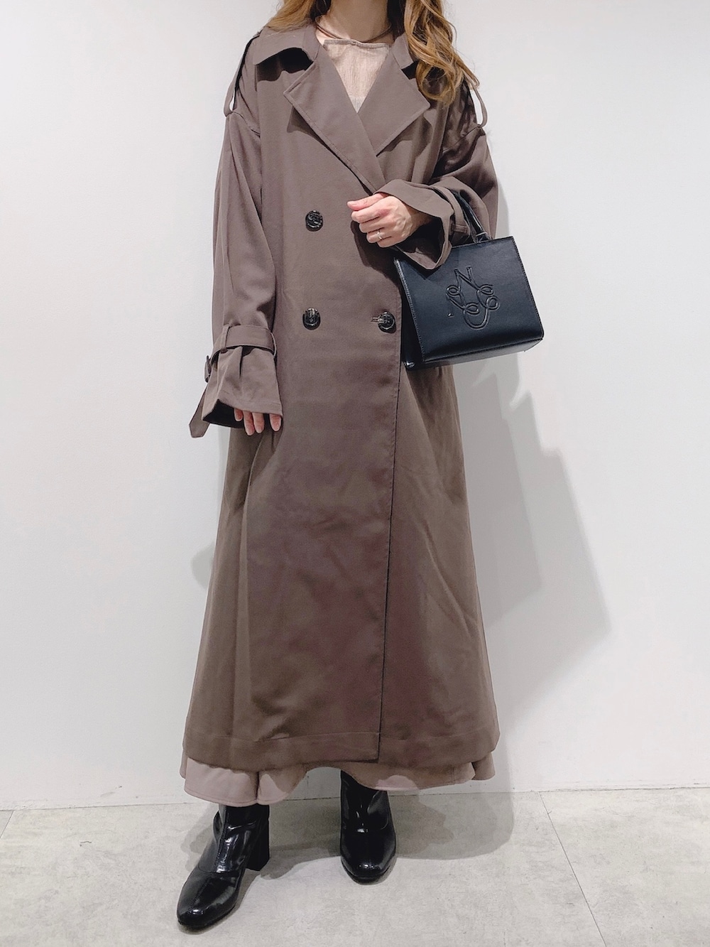 ブラウン系のトレンチコート、ブラウン系のシャツ/ブラウス、ブラウン系のスカートを着用したレディースの秋コーディネートの2枚目の写真