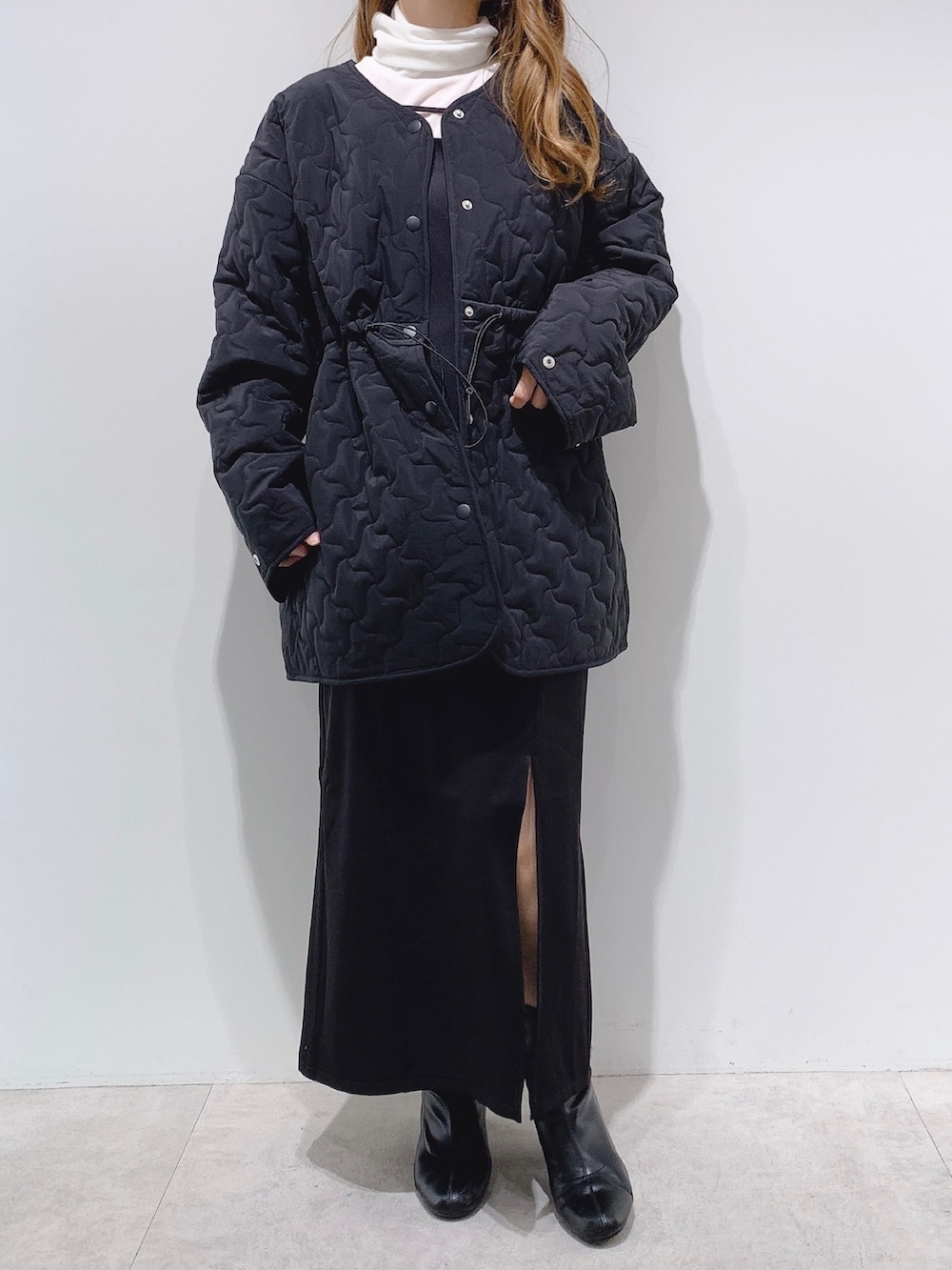 ブラック系のノーカラーコート、ホワイト系のTシャツ/カットソー、ブラック系のワンピースを着用したレディースの秋コーディネートの2枚目の写真