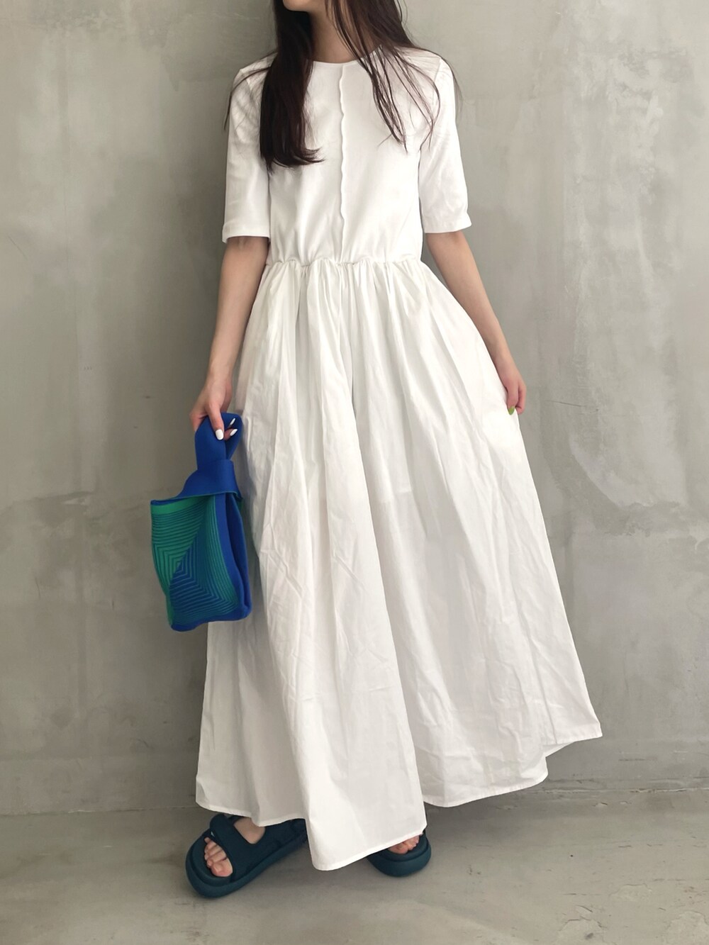 ホワイト系のワンピース、ブルー系のハンドバッグを着用したレディースの春コーディネートの2枚目の写真