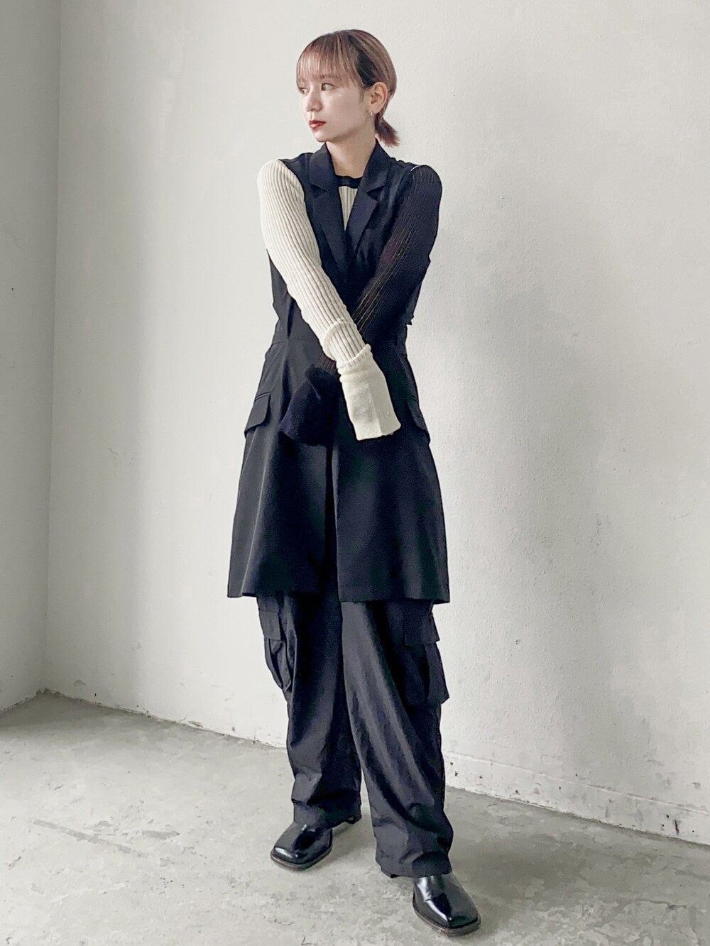 ブラック系のベスト、ホワイト系のニット/セーターを着用したメンズの秋コーディネートの2枚目の写真