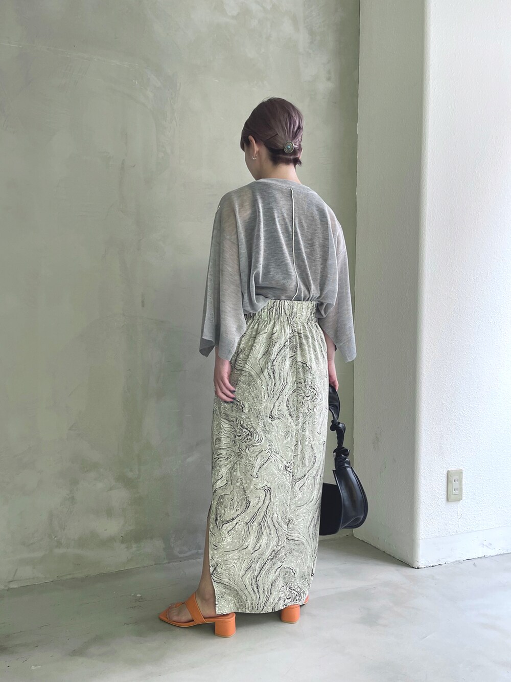 ブラック系のニット/セーターを着用したレディースの夏コーディネートの2枚目の写真