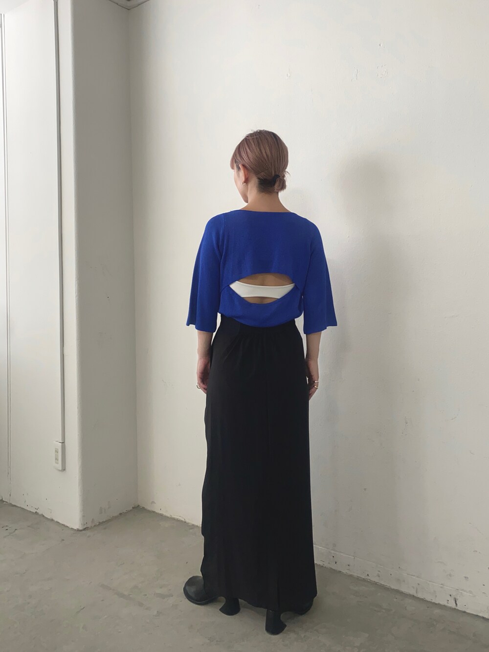 ブルー系のニット/セーター、ブラック系のスカートを着用したレディースの夏コーディネートの2枚目の写真