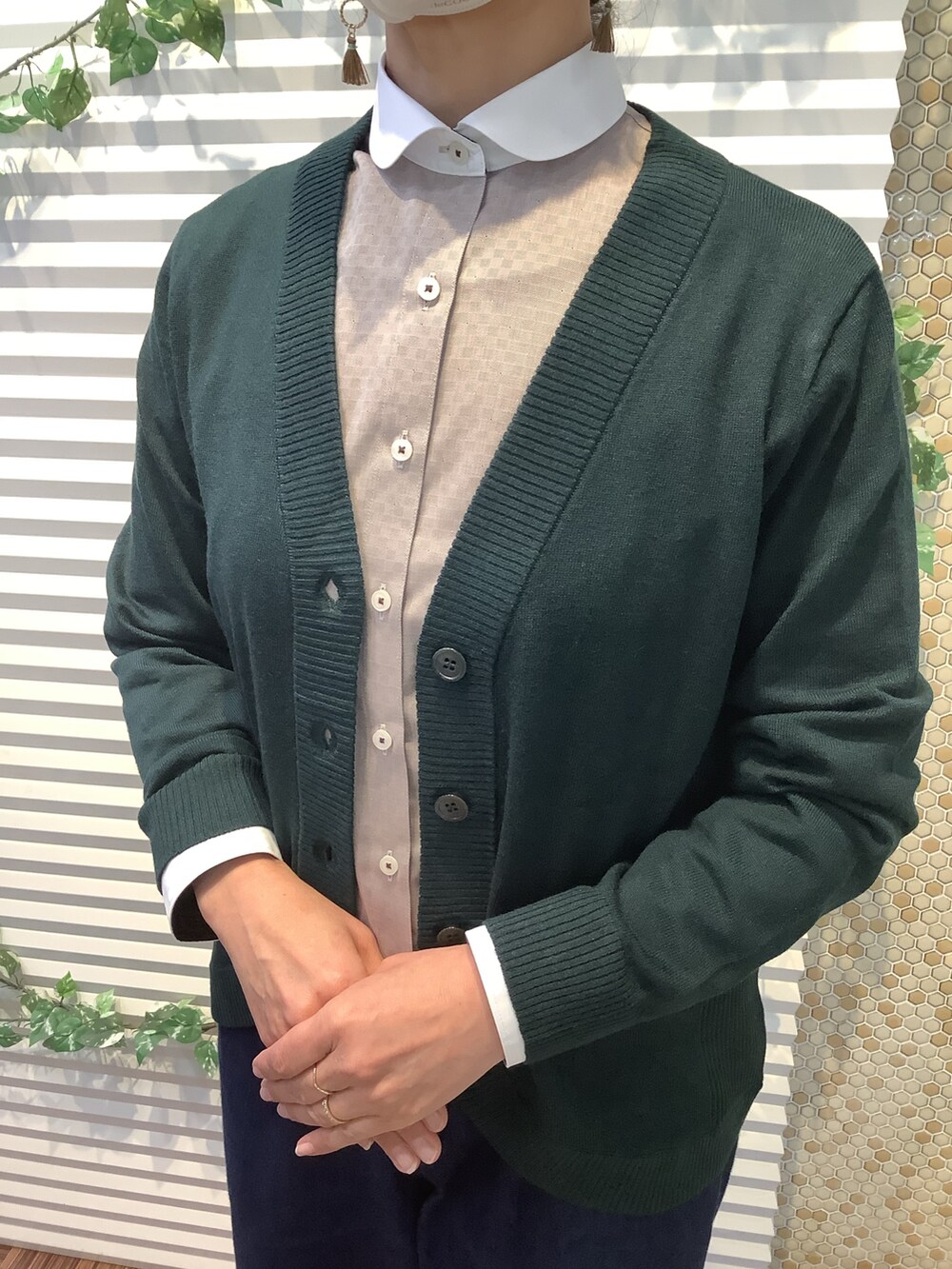 グリーン系のカーディガン/ボレロ、ブラウン系のビジネスシャツを着用したレディースの冬コーディネートの2枚目の写真