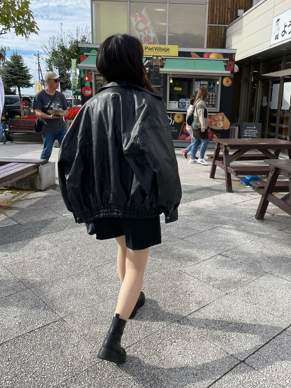 グレー系のカーディガン/ボレロ、ブラック系のブーツ、ブラック系のブルゾンを着用したレディースの秋コーディネートの2枚目の写真
