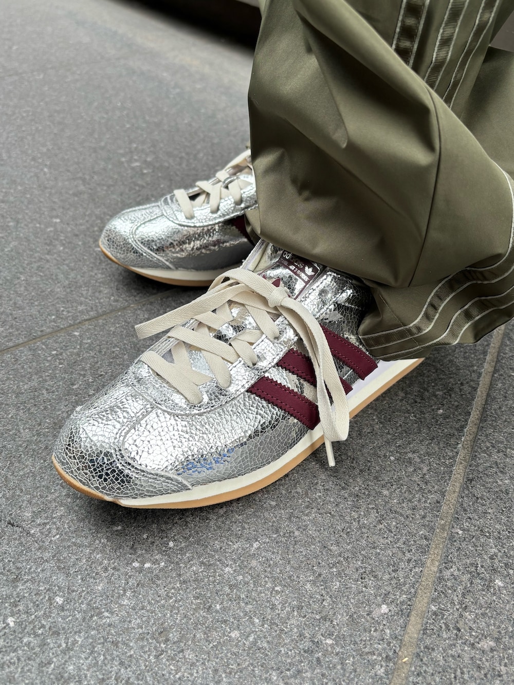 ブラック系のトップス、グリーン系のカーゴパンツ、シルバー系のスニーカーを着用したレディースの冬コーディネートの2枚目の写真