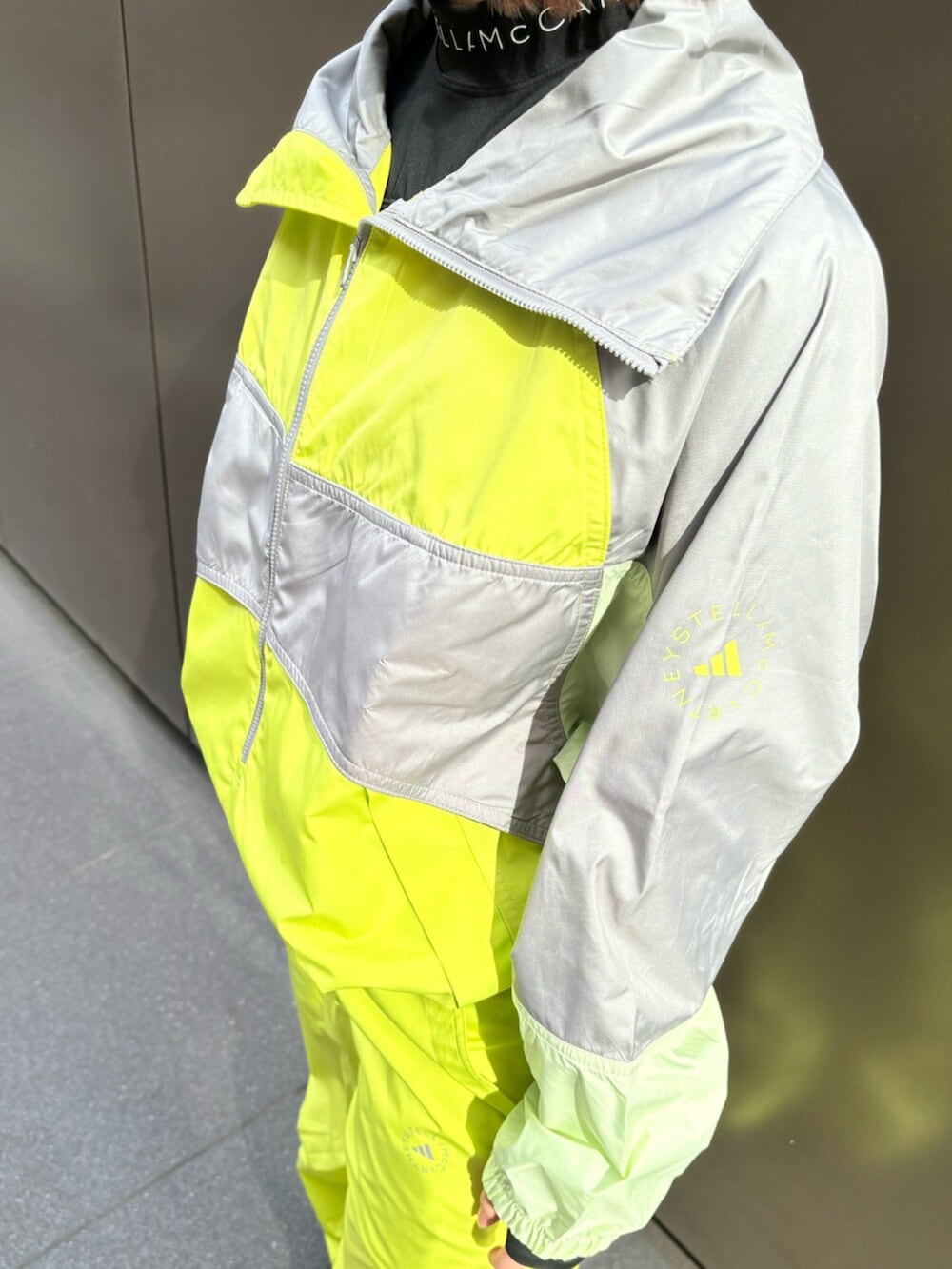 ブラック系のその他トップス、イエロー系のナイロンジャケット、イエロー系のその他パンツを着用したレディースの冬コーディネートの2枚目の写真