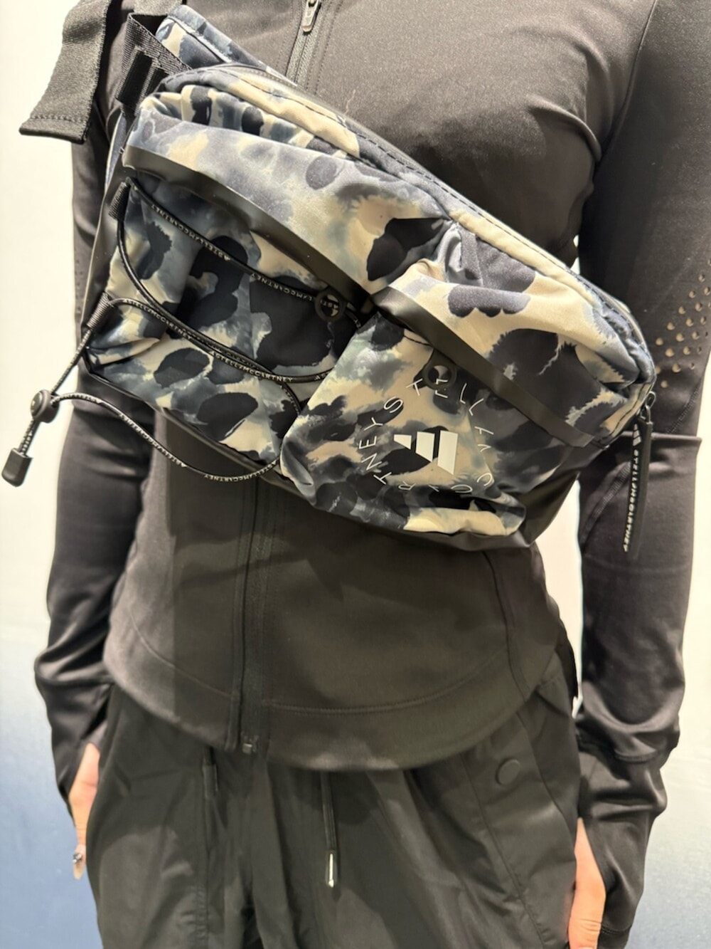 ブラック系のスニーカー、グレー系のボディバッグ/ウエストポーチ、ブラック系のジャケット/アウターを着用したレディースの冬コーディネートの3枚目の写真