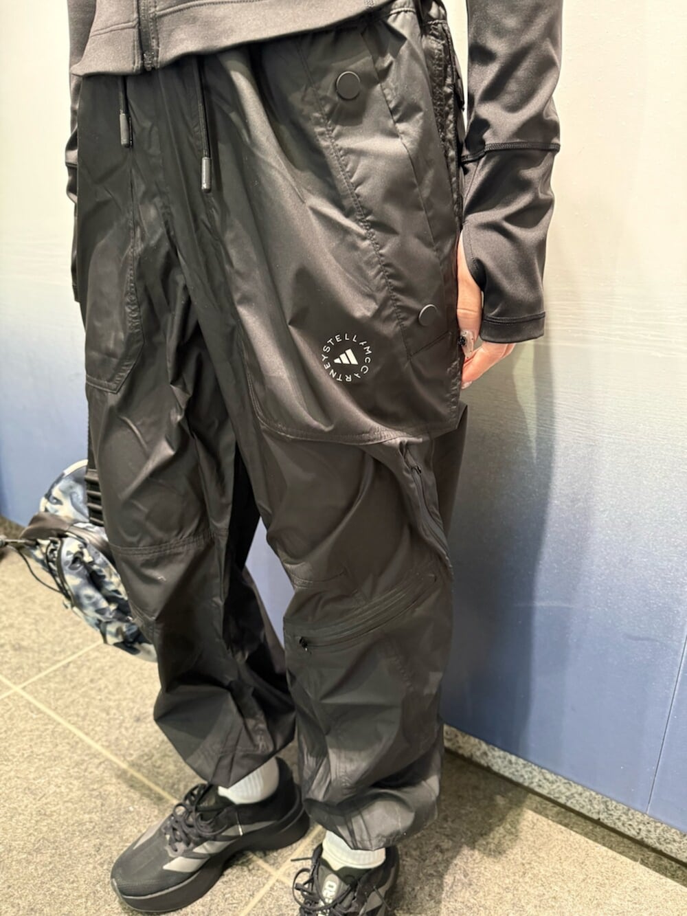 ブラック系のスニーカー、グレー系のボディバッグ/ウエストポーチ、ブラック系のジャケット/アウターを着用したレディースの冬コーディネートの5枚目の写真