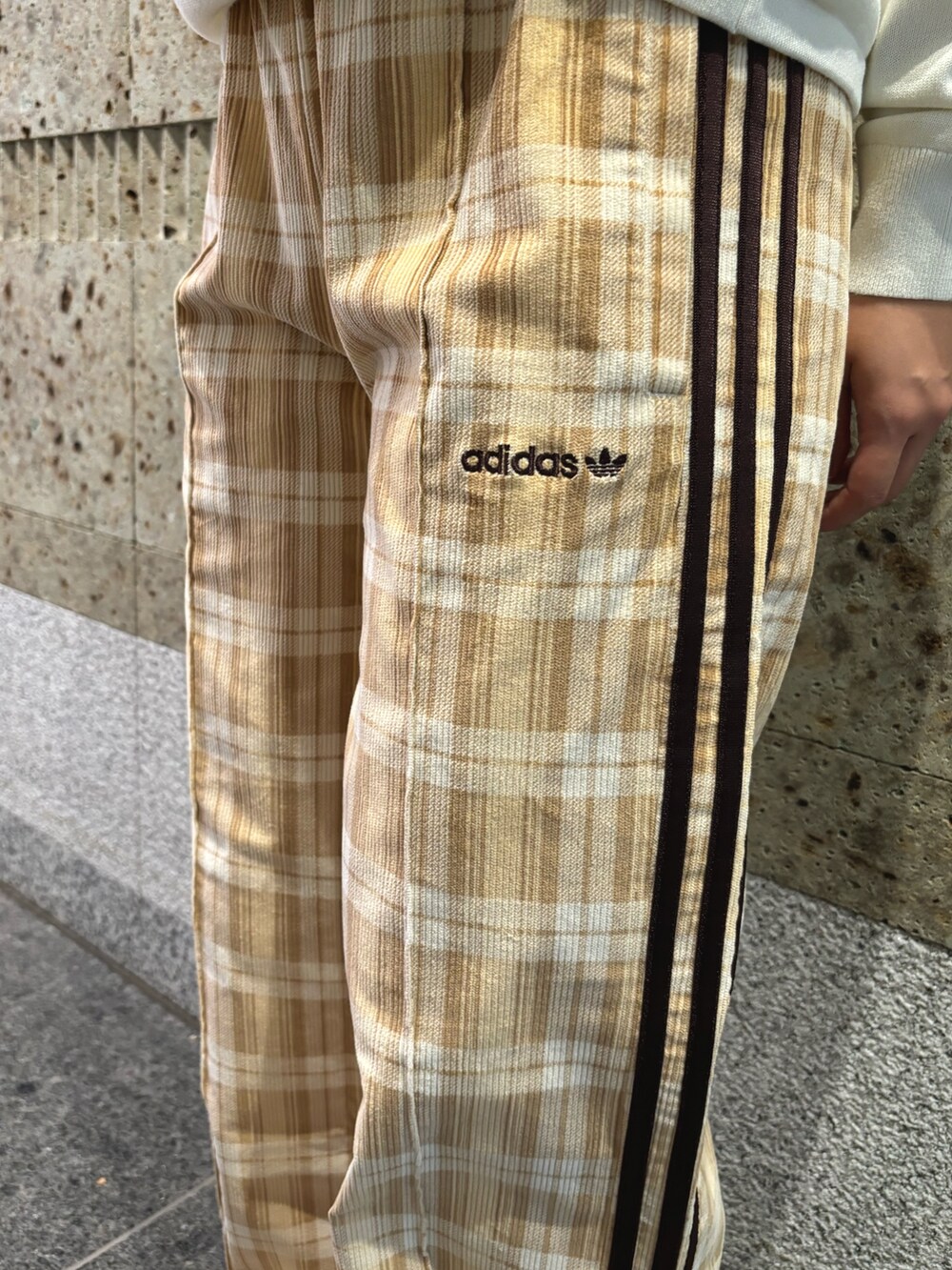 ホワイト系のポロシャツ、ベージュ系のその他パンツ、ベージュ系のスニーカーを着用したレディースの秋コーディネートの3枚目の写真