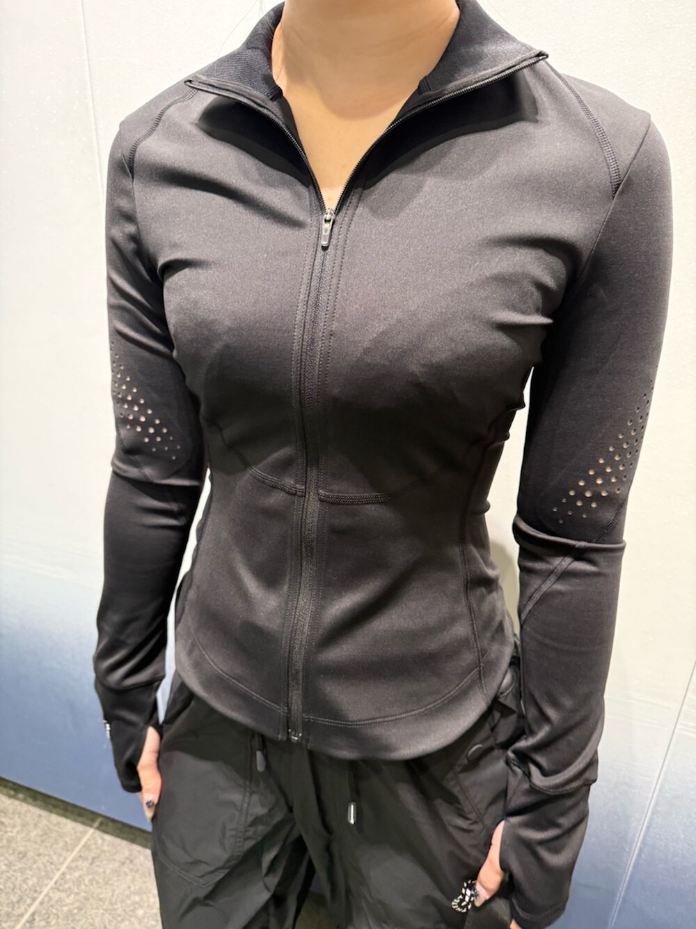 ブラック系のスニーカー、グレー系のボディバッグ/ウエストポーチ、ブラック系のジャケット/アウターを着用したレディースの冬コーディネートの4枚目の写真