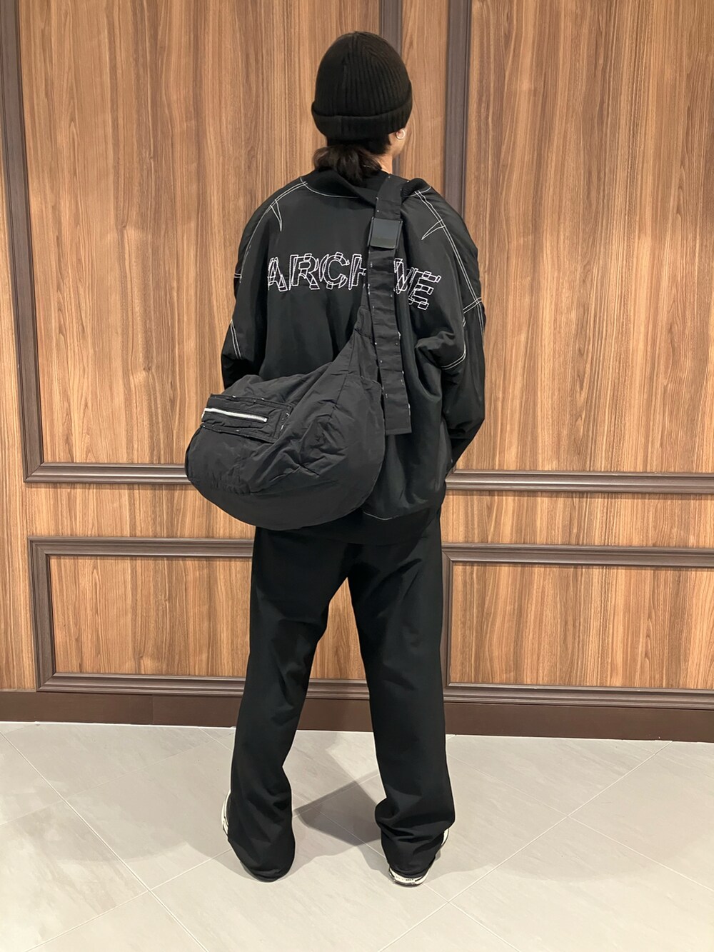 ブラック系のMA-1、ブラック系のショルダーバッグを着用したメンズの冬コーディネートの3枚目の写真