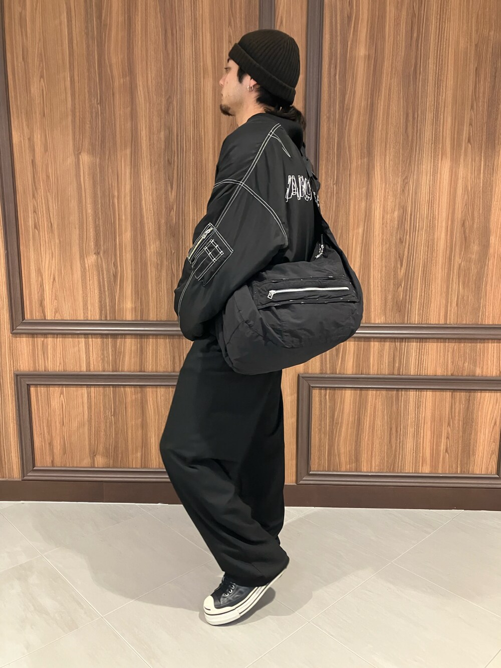 ブラック系のMA-1、ブラック系のショルダーバッグを着用したメンズの冬コーディネートの2枚目の写真