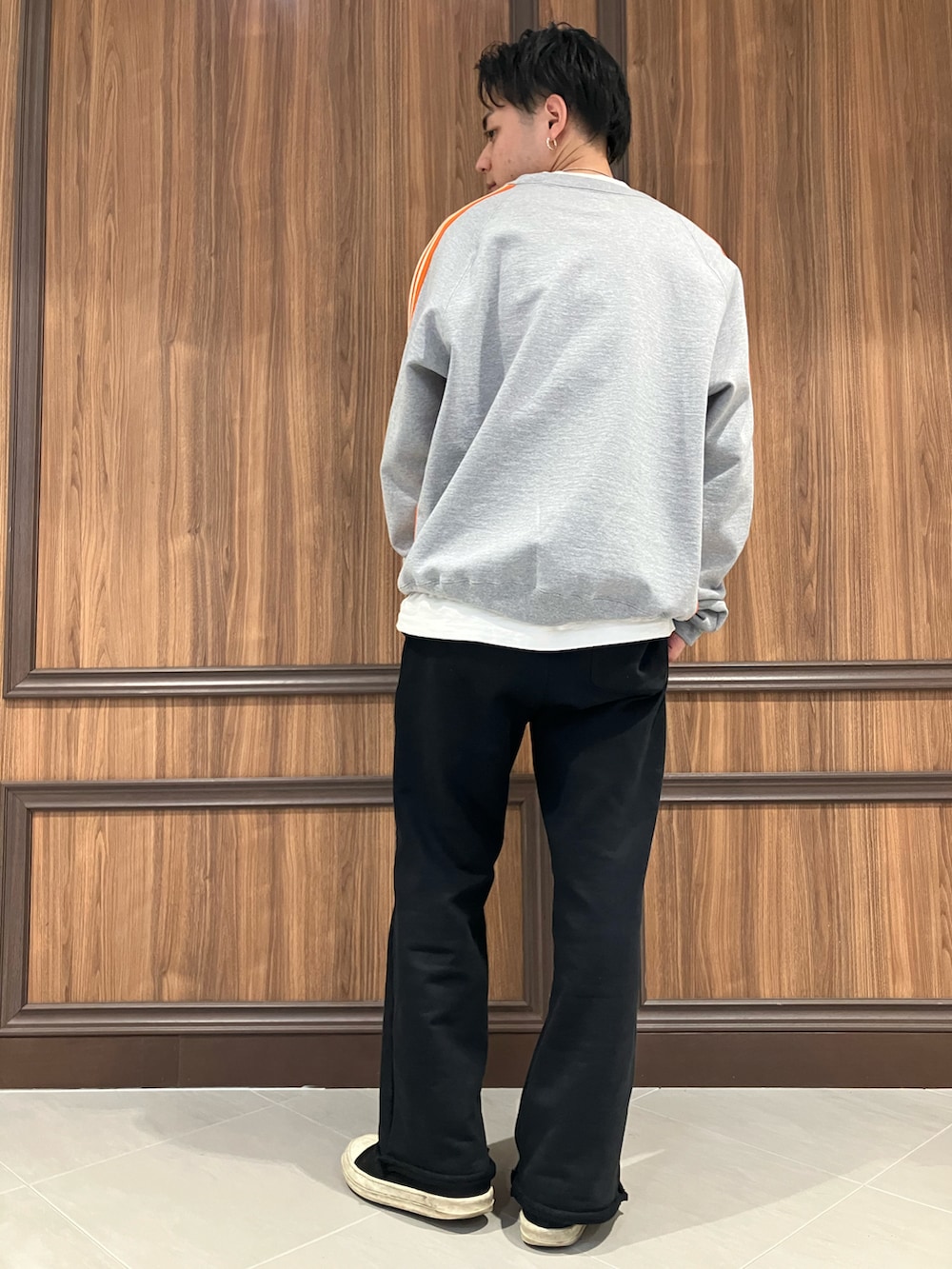 オレンジ系のスウェット、ブラック系のスウェットパンツを着用したメンズの冬コーディネートの3枚目の写真