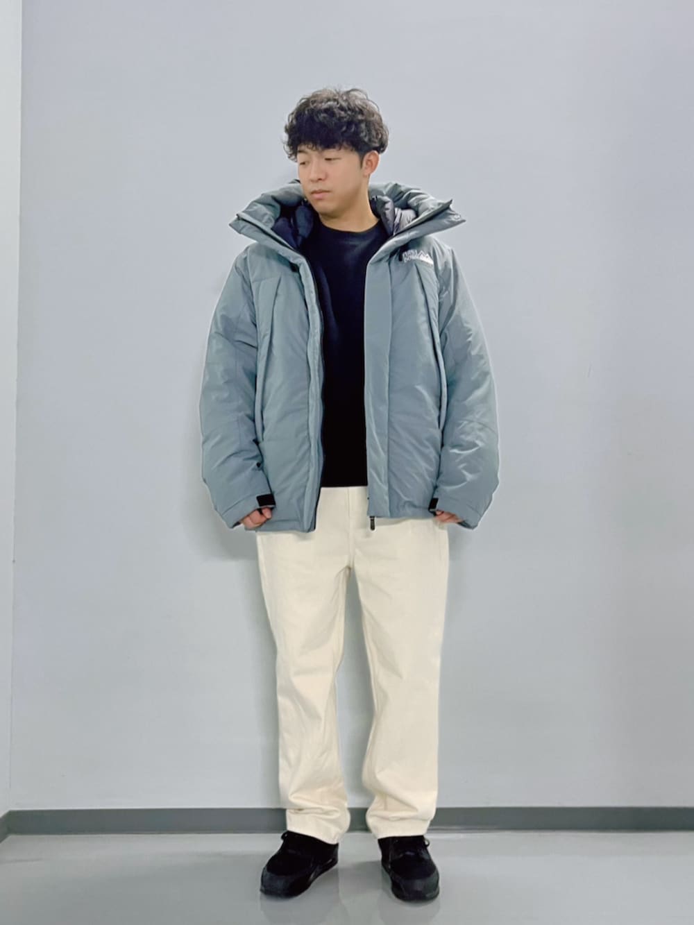 グレー系のダウンジャケット/コート、ブラック系のスウェット、ホワイト系のデニムパンツを着用したメンズの秋コーディネートの2枚目の写真