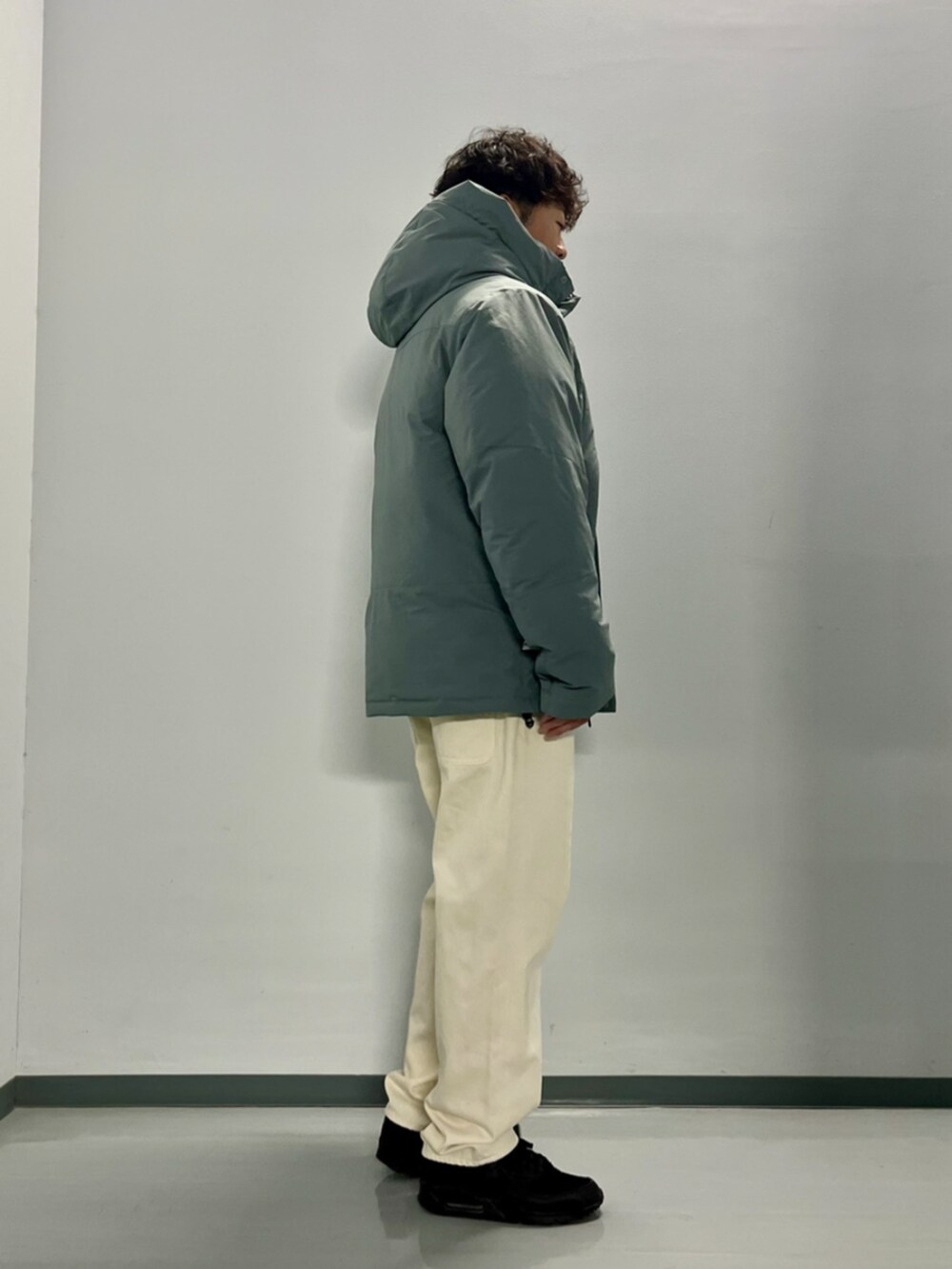 グレー系のダウンジャケット/コート、ブラック系のスウェット、ホワイト系のデニムパンツを着用したメンズの秋コーディネートの8枚目の写真