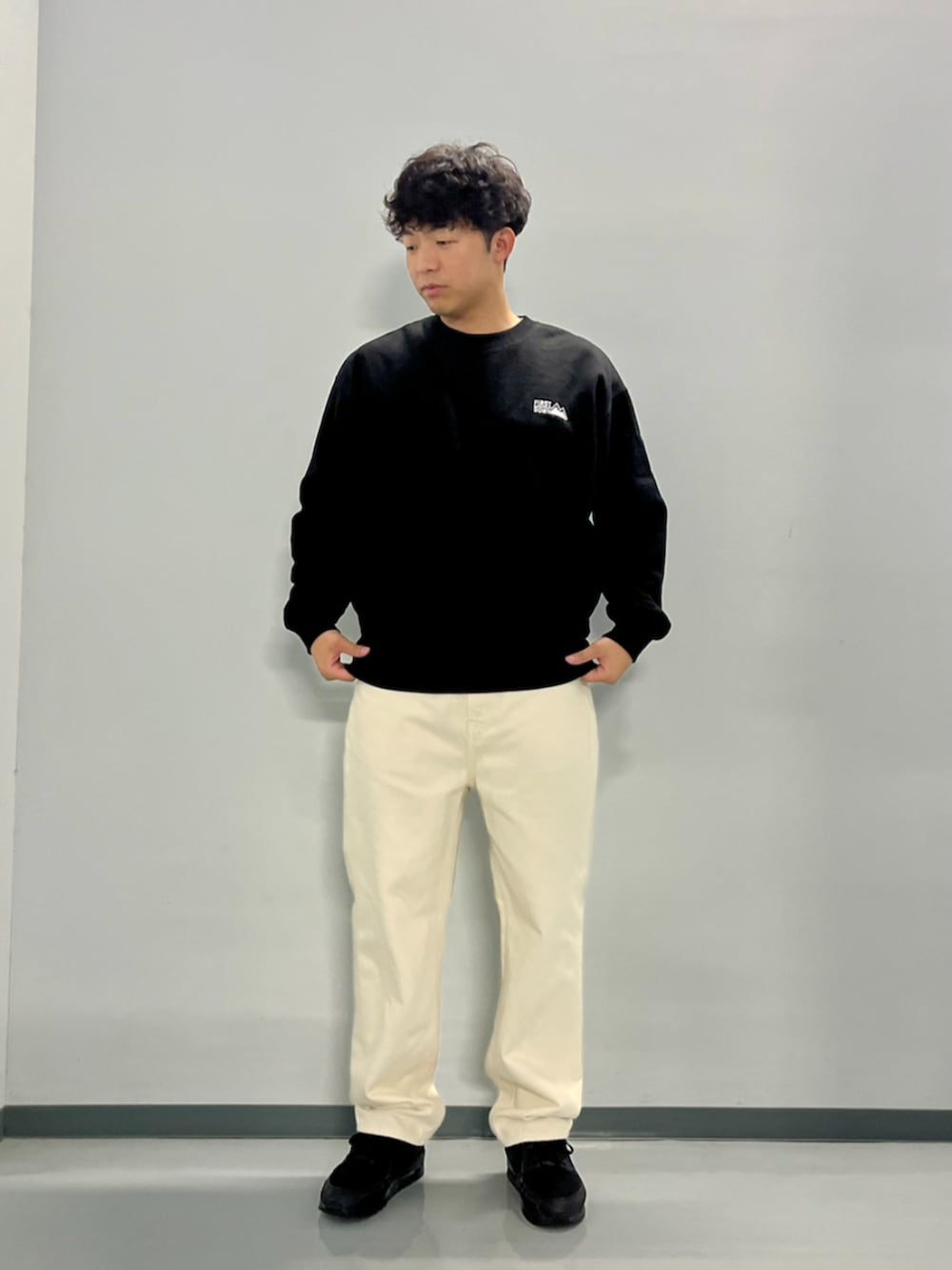 グレー系のダウンジャケット/コート、ブラック系のスウェット、ホワイト系のデニムパンツを着用したメンズの秋コーディネートの10枚目の写真