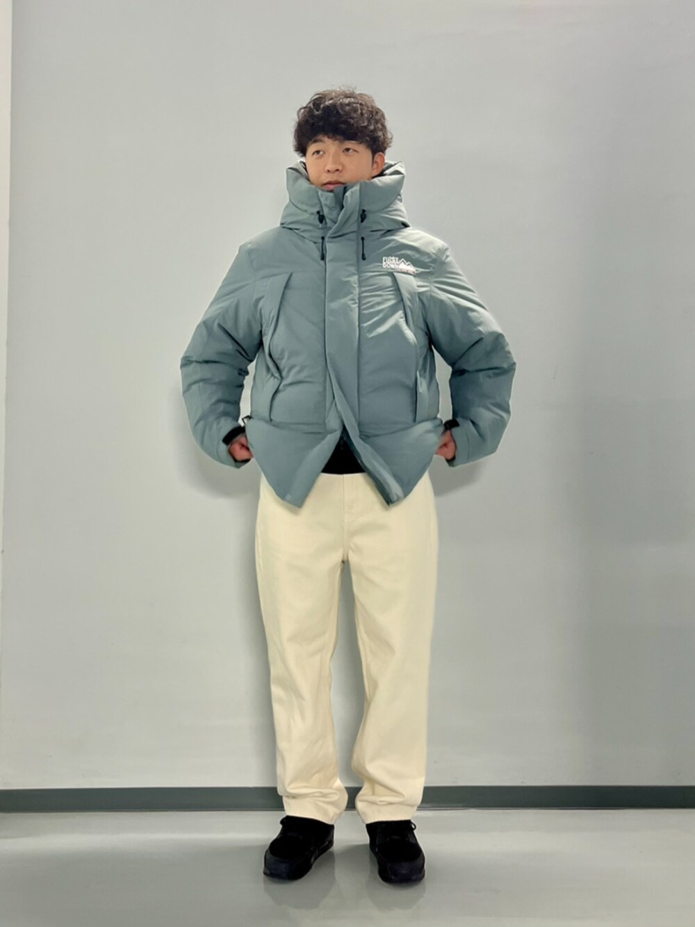 グレー系のダウンジャケット/コート、ブラック系のスウェット、ホワイト系のデニムパンツを着用したメンズの秋コーディネートの9枚目の写真