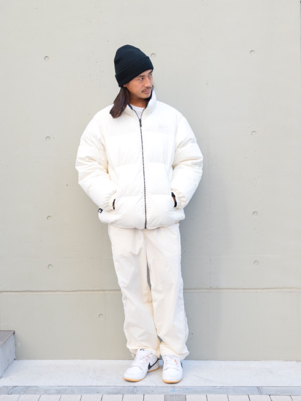 ホワイト系のデニムパンツ、ホワイト系のダウンジャケット/コートを着用したメンズの秋コーディネートの2枚目の写真