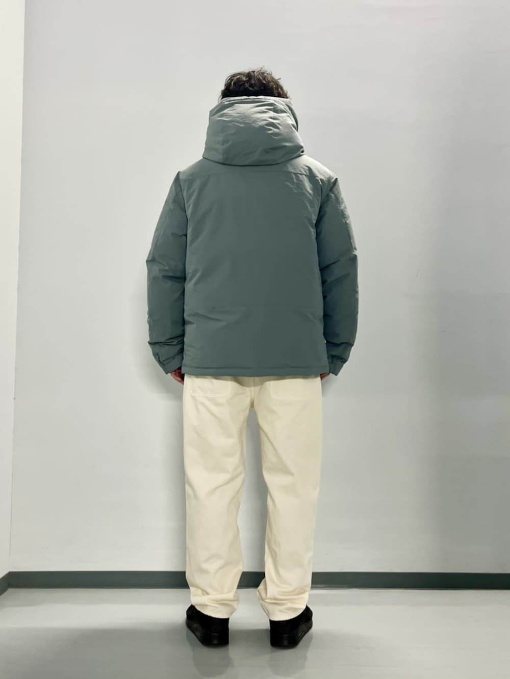 グレー系のダウンジャケット/コート、ブラック系のスウェット、ホワイト系のデニムパンツを着用したメンズの秋コーディネートの7枚目の写真