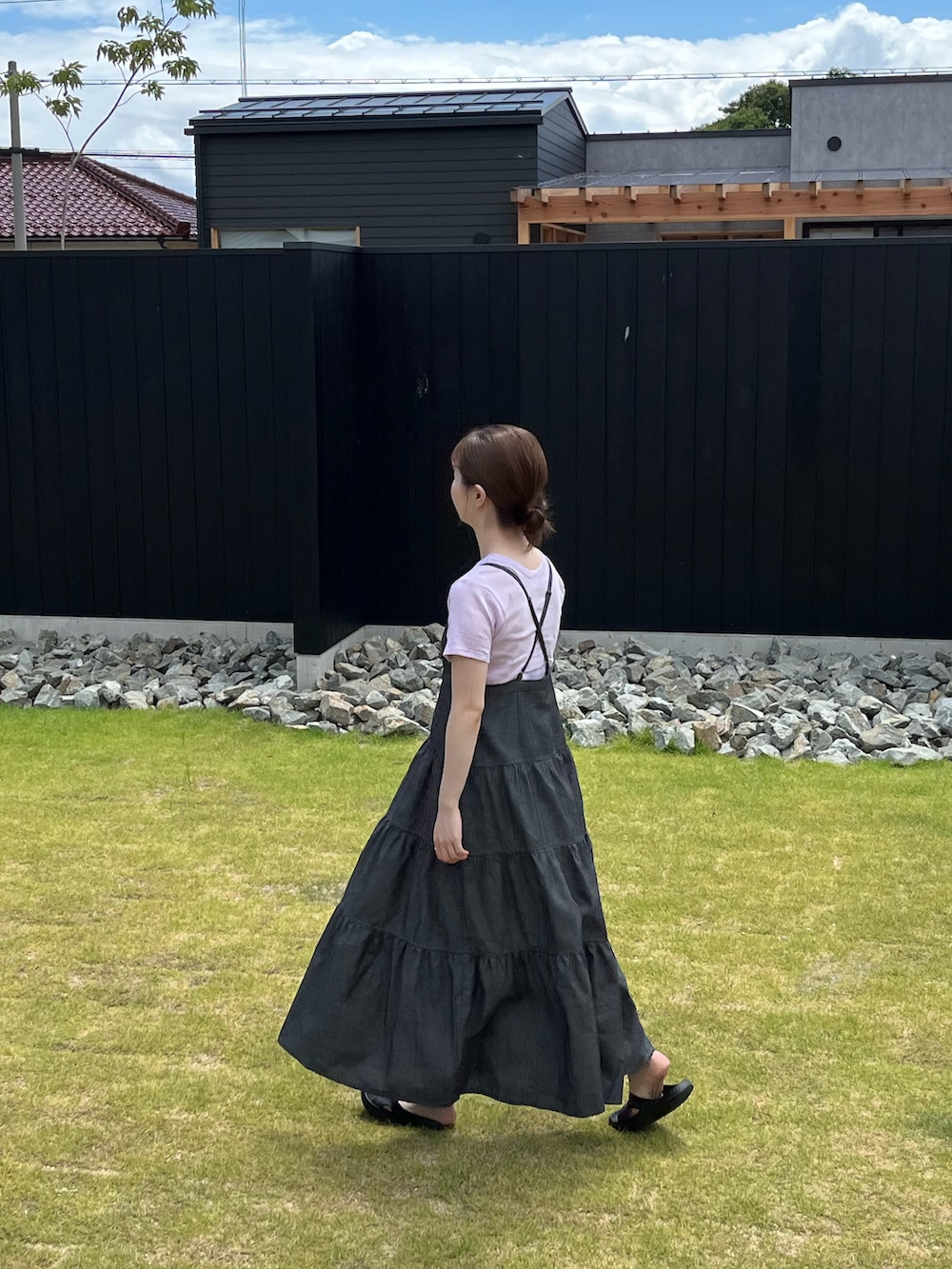 ブラック系のジャンパースカート、パープル系のTシャツ/カットソーを着用したレディースの夏コーディネートの2枚目の写真