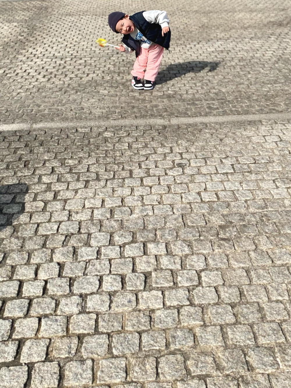 ピンク系のスウェットパンツ、ブラック系のダウンベスト、ホワイト系のスウェットを着用したキッズの冬コーディネートの2枚目の写真